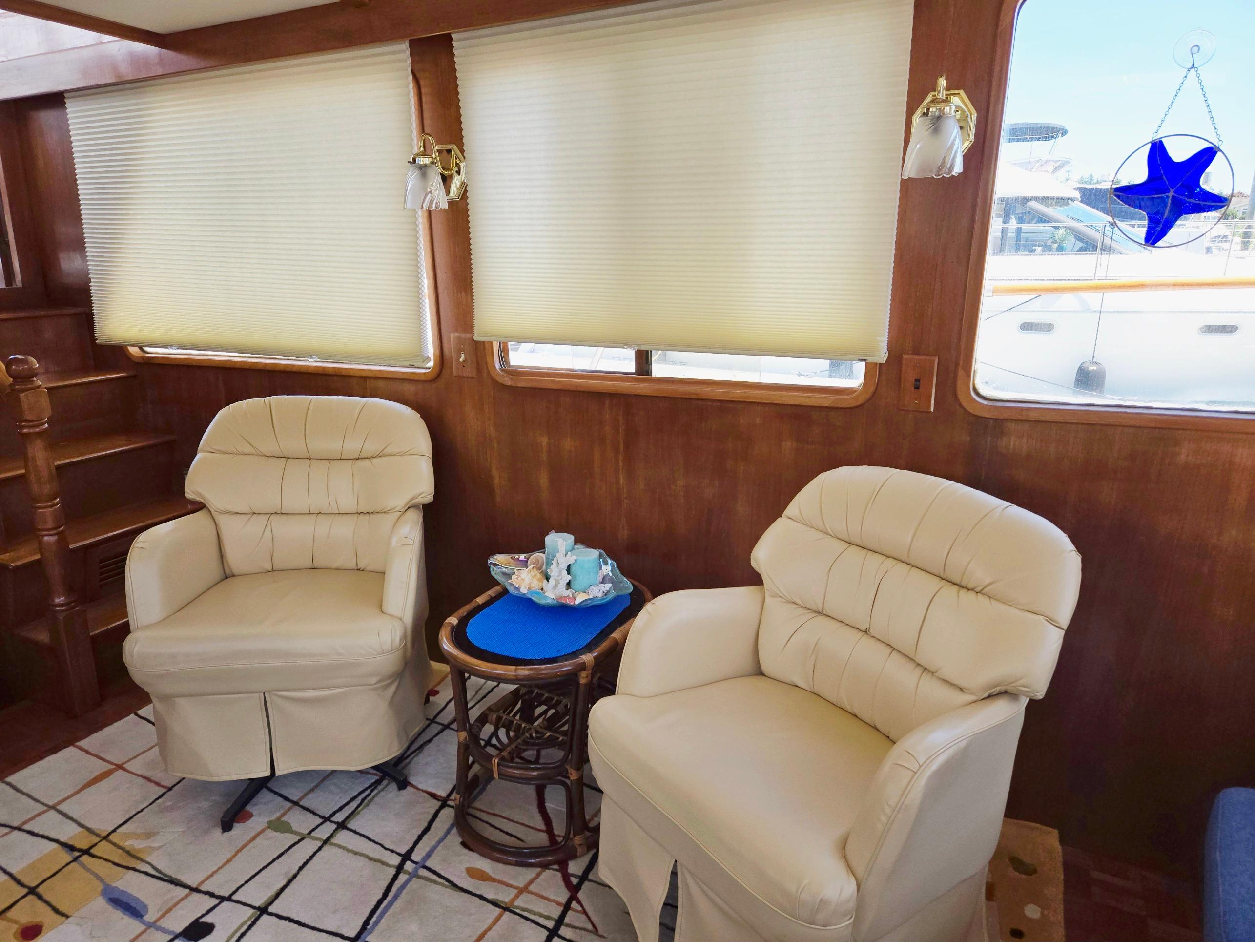 Interior of 1983 Ocean Alexander 43 yacht with plush chairs and nautical decor.