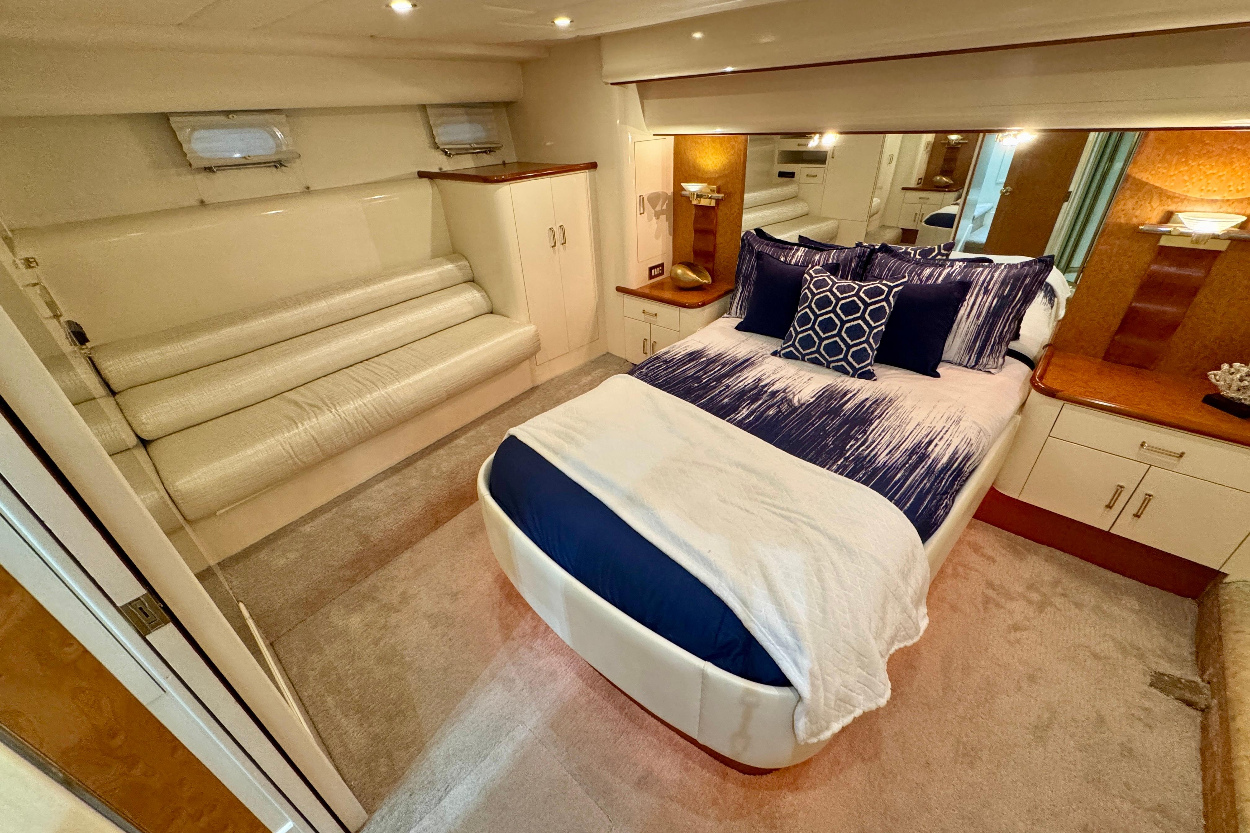 Luxurious bedroom in 1995 Queenship 62 Pilothouse Motor Yacht with elegant decor and plush bedding.