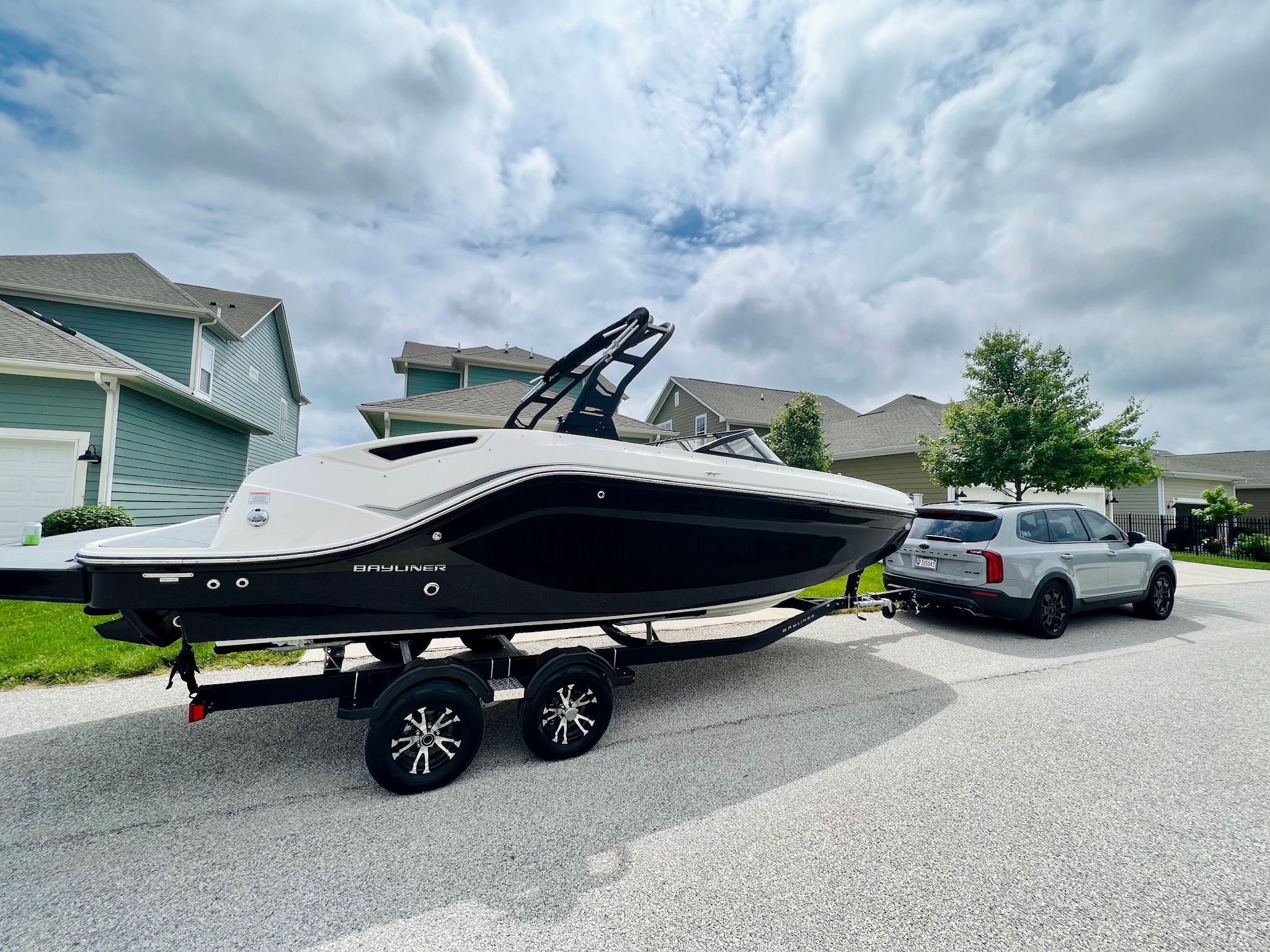 2022 Bayliner DX 2250 boat on trailer, parked in suburban neighborhood.