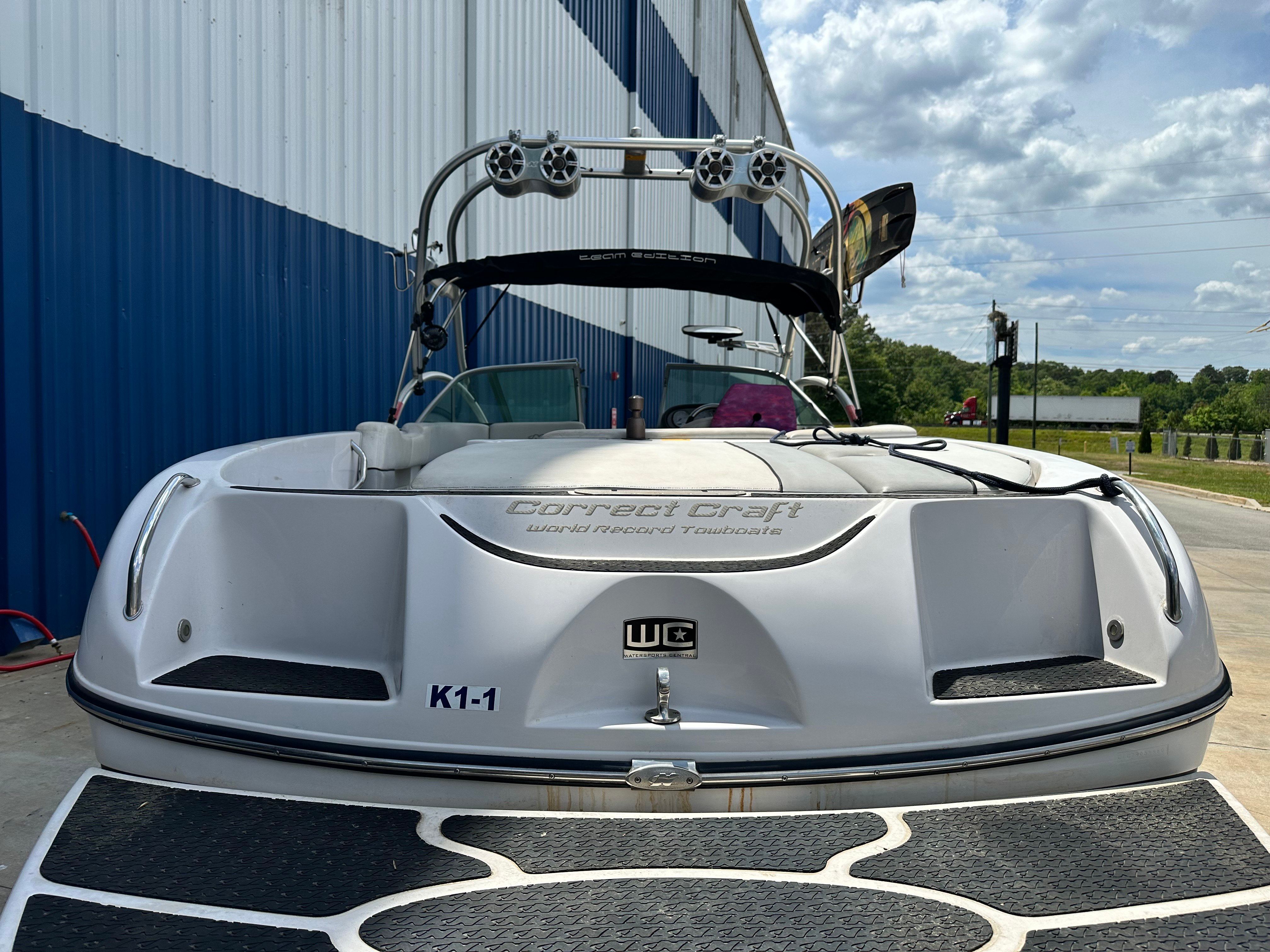 A white 2007 Nautique SV 211 boat on a trailer in front of a building.