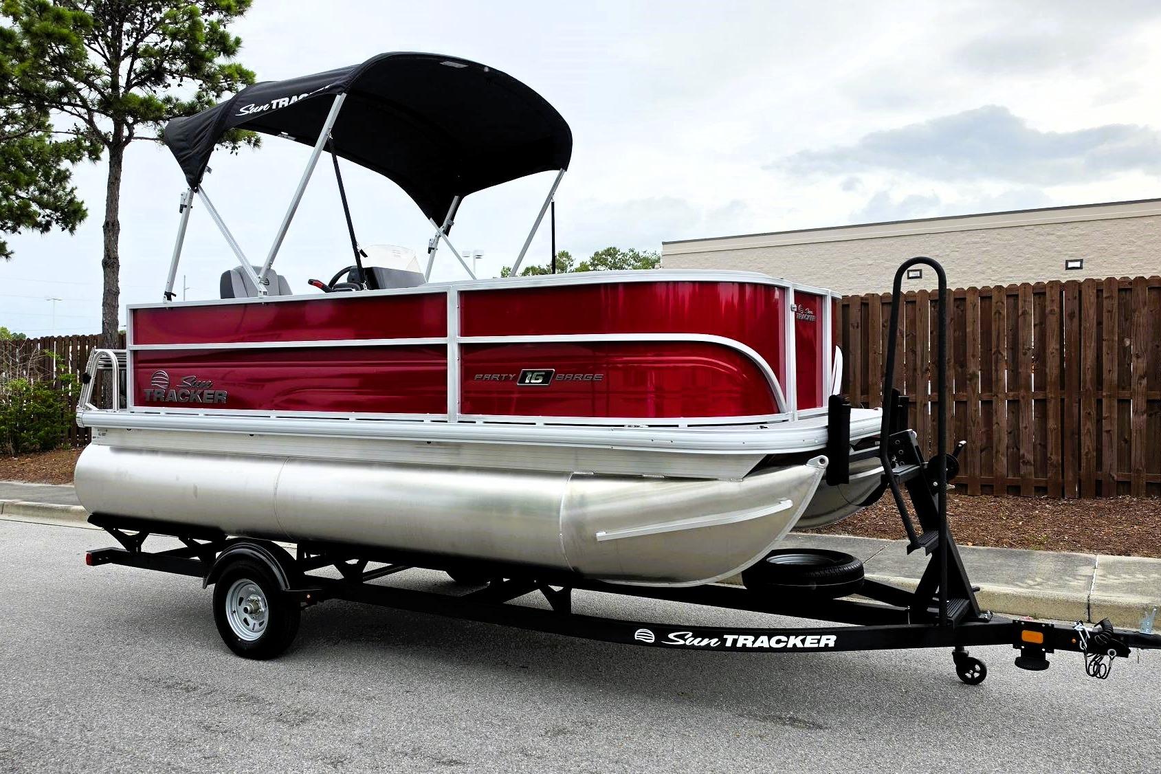 2026 Sun Tracker Party Barge 16 DLX pontoon boat on trailer, parked outdoors.