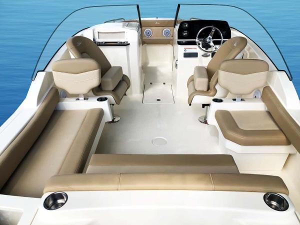 2025 Scout 215 Dorado boat interior with beige seating and modern dashboard on blue water.