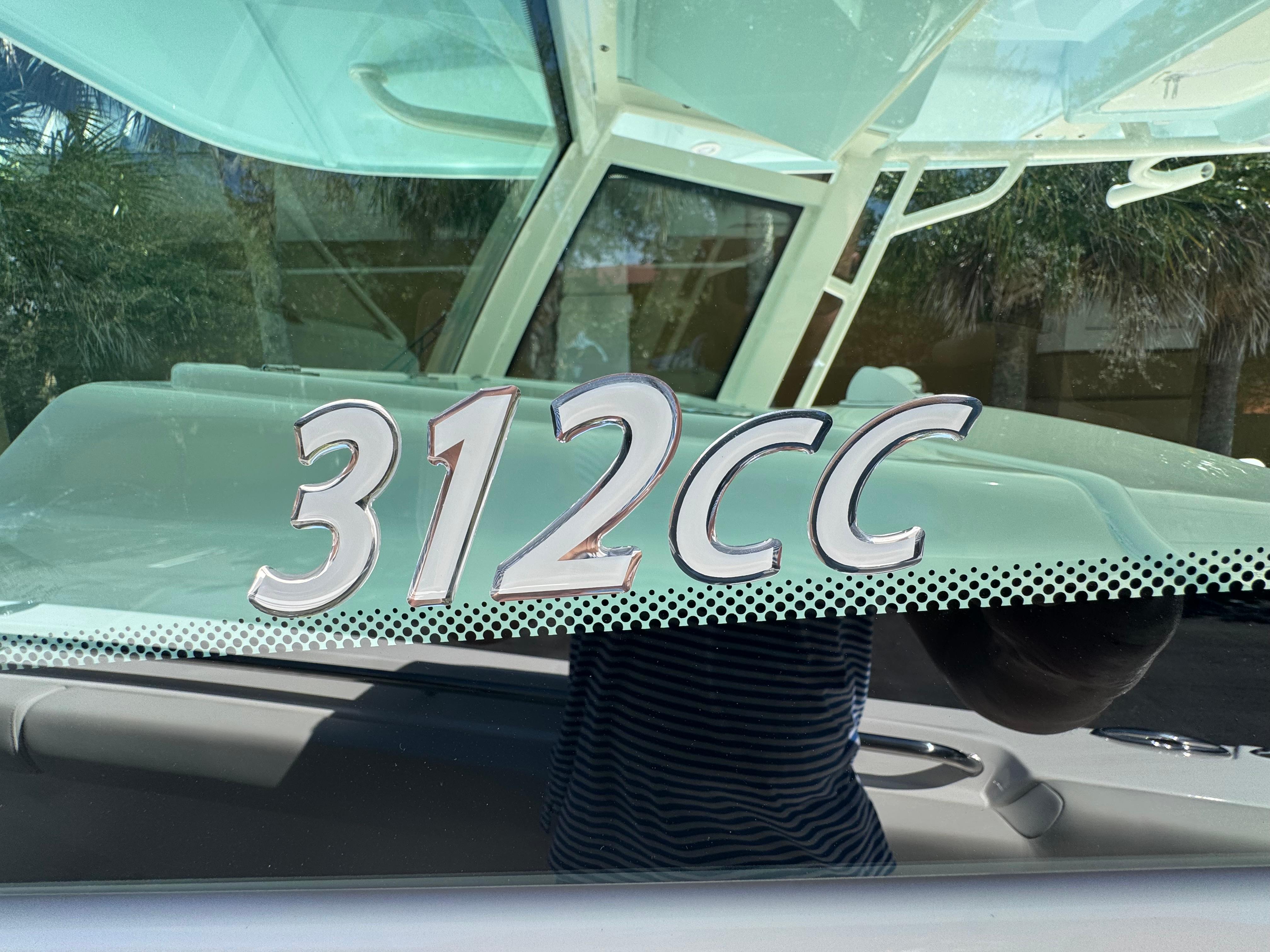 2026 Sailfish 312 CC boat model emblem on glass surface.