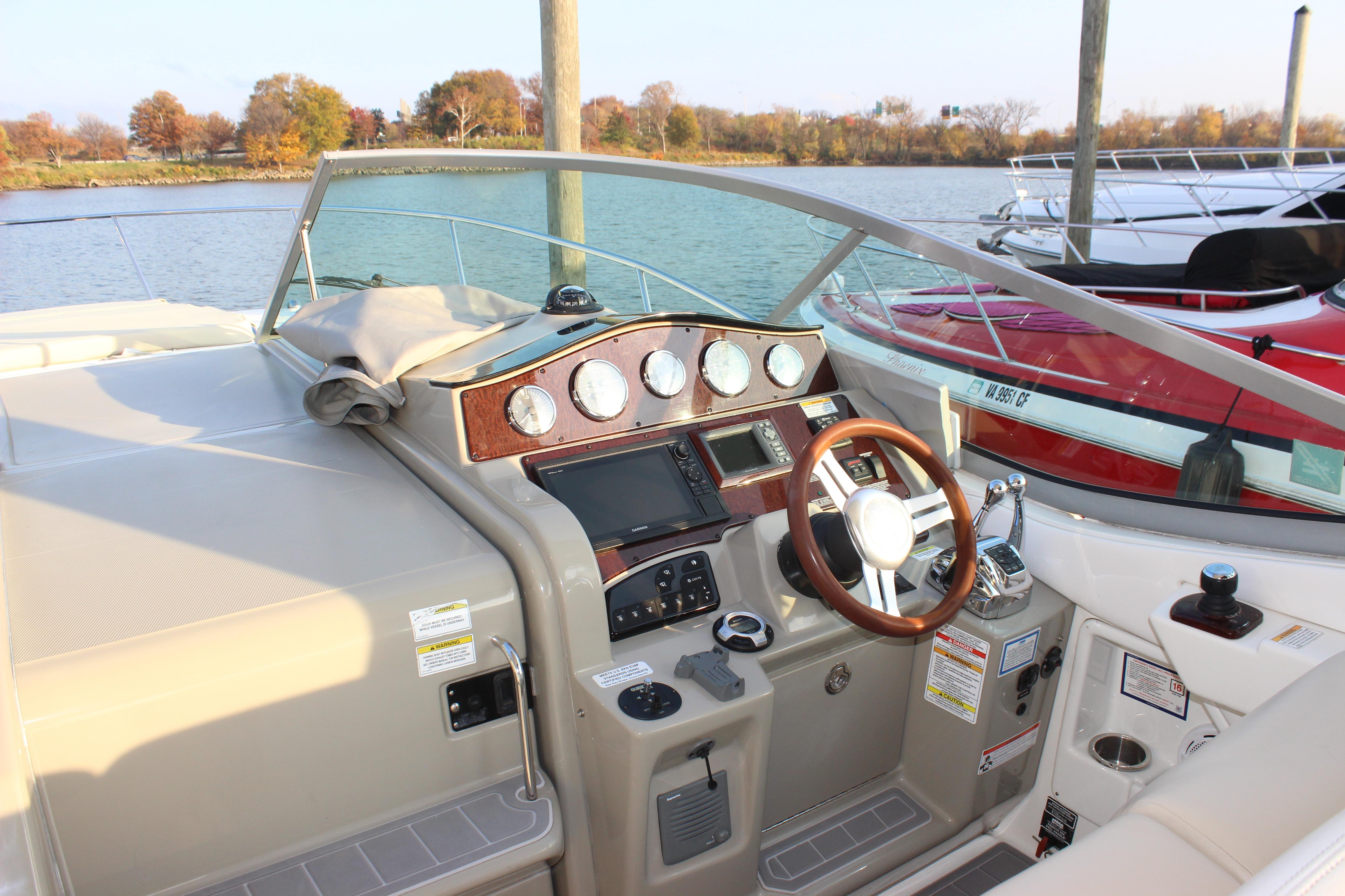 Cockpit of 2012 Sea Ray 330 Sundancer with steering wheel and control panel.