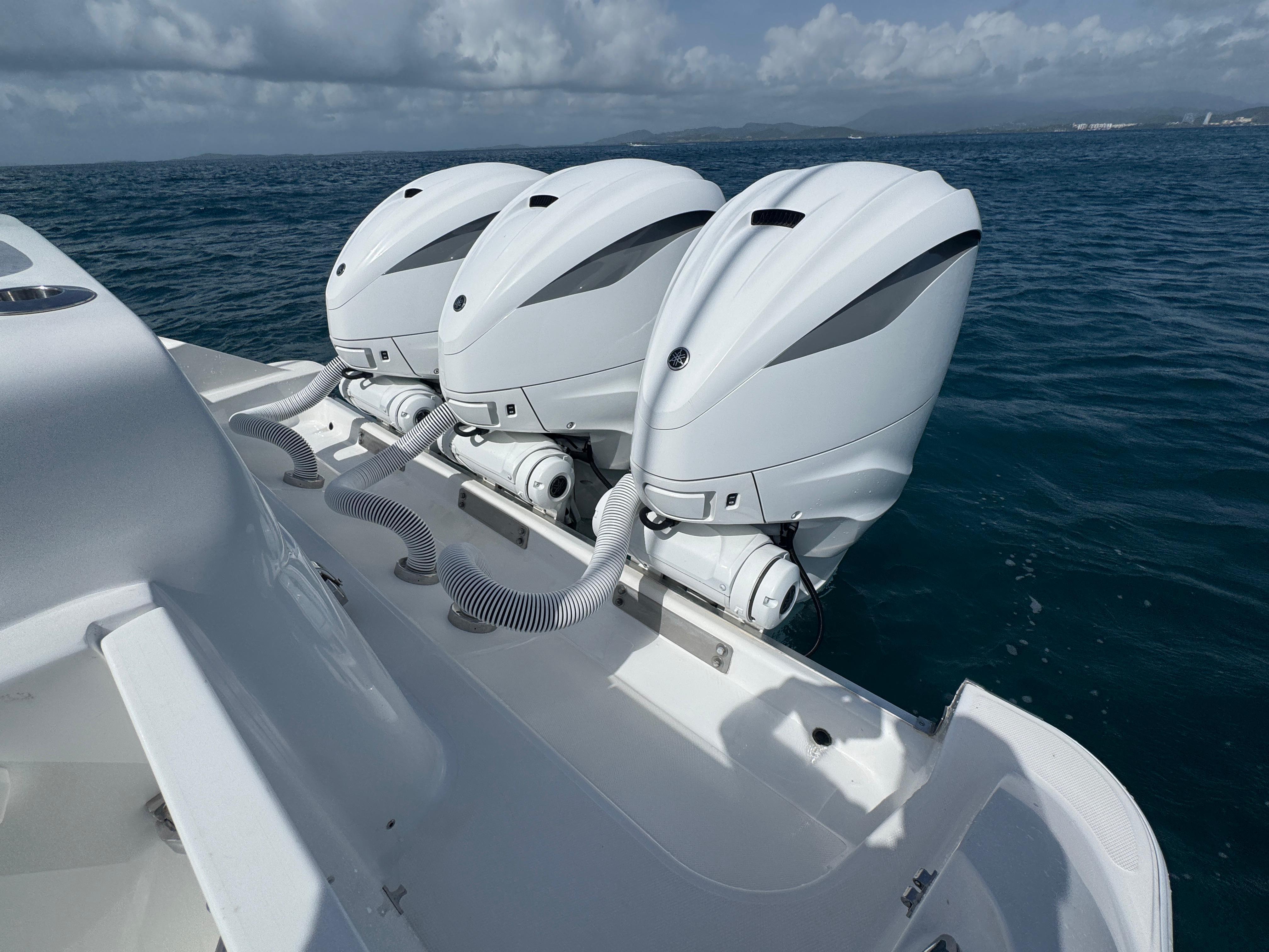Triple outboard engines on a 2023 HCB 42 Lujo boat in open water.