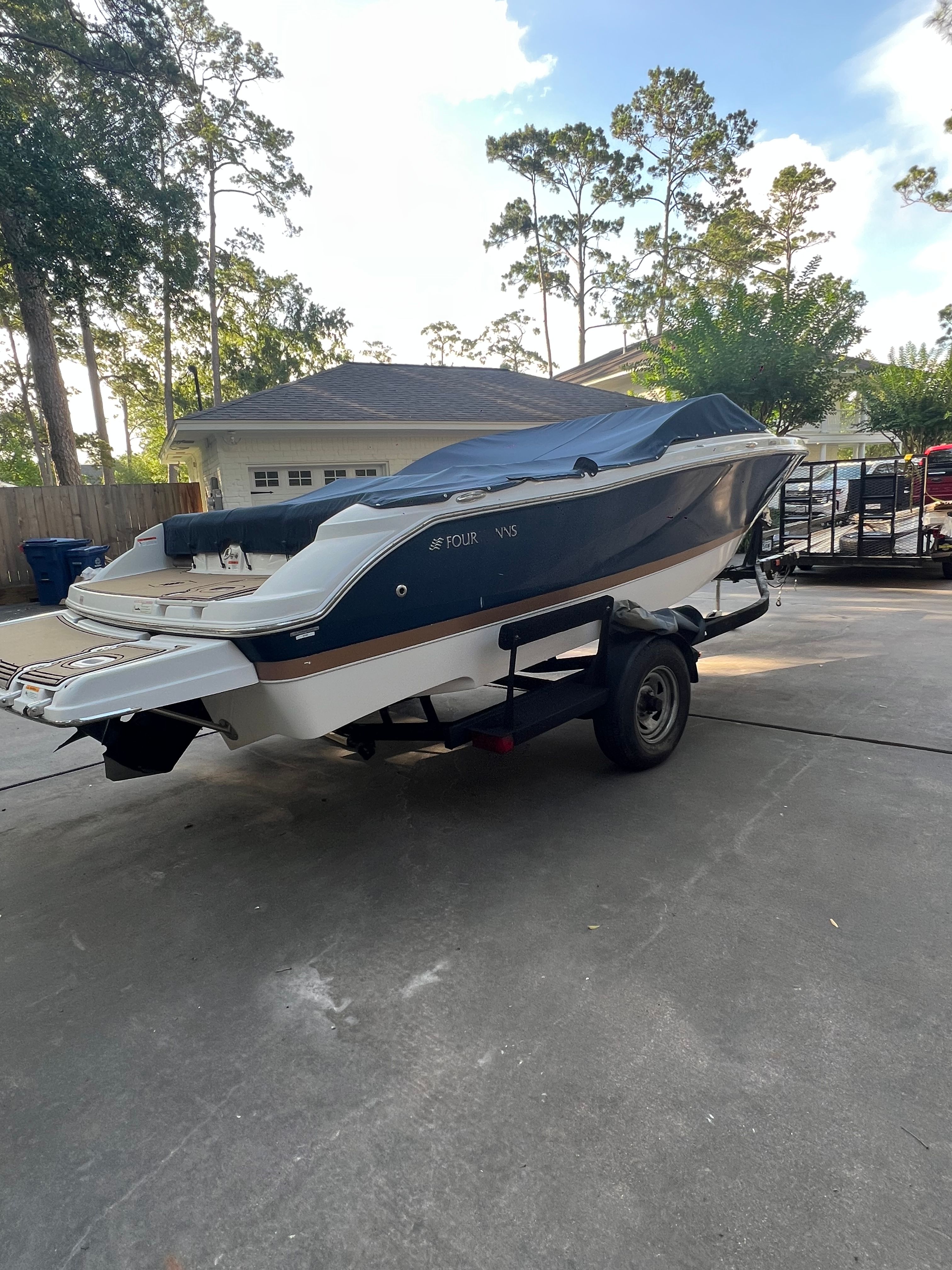 2017 Four Winns H230 boat parked on trailer outdoors.