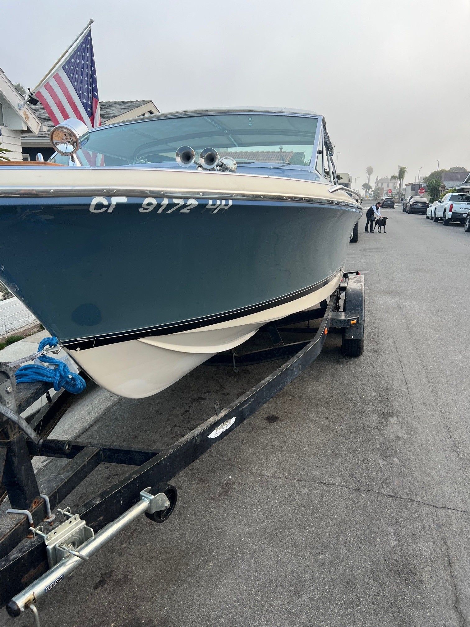 1985 Century Coronado Cardel boat on trailer, parked on street with American flag.