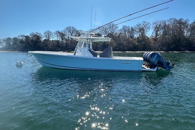 2015 Regulator 34 boat on calm water, surrounded by trees.
