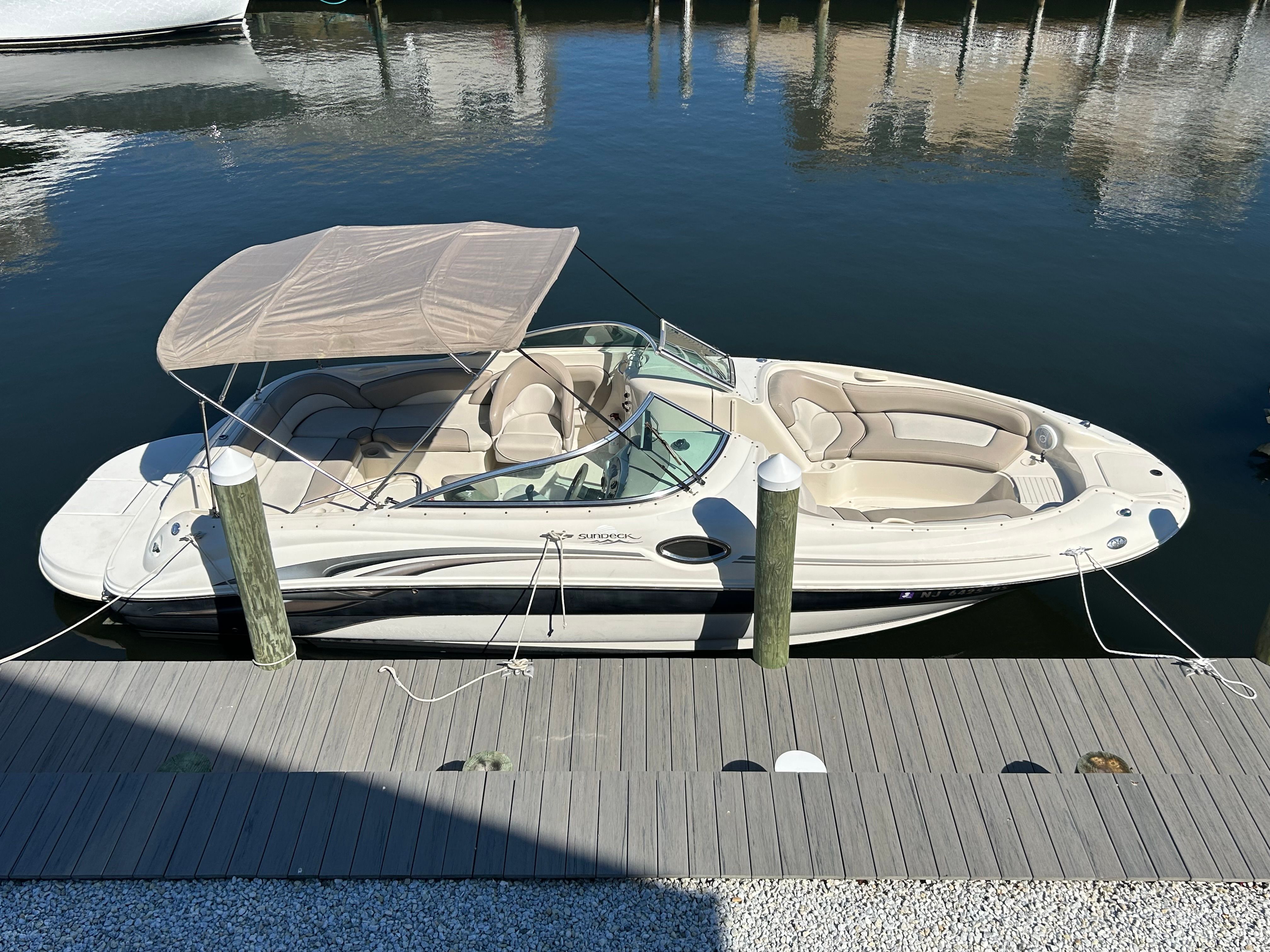 2003 Sea Ray 240 Sundeck boat docked at pier.