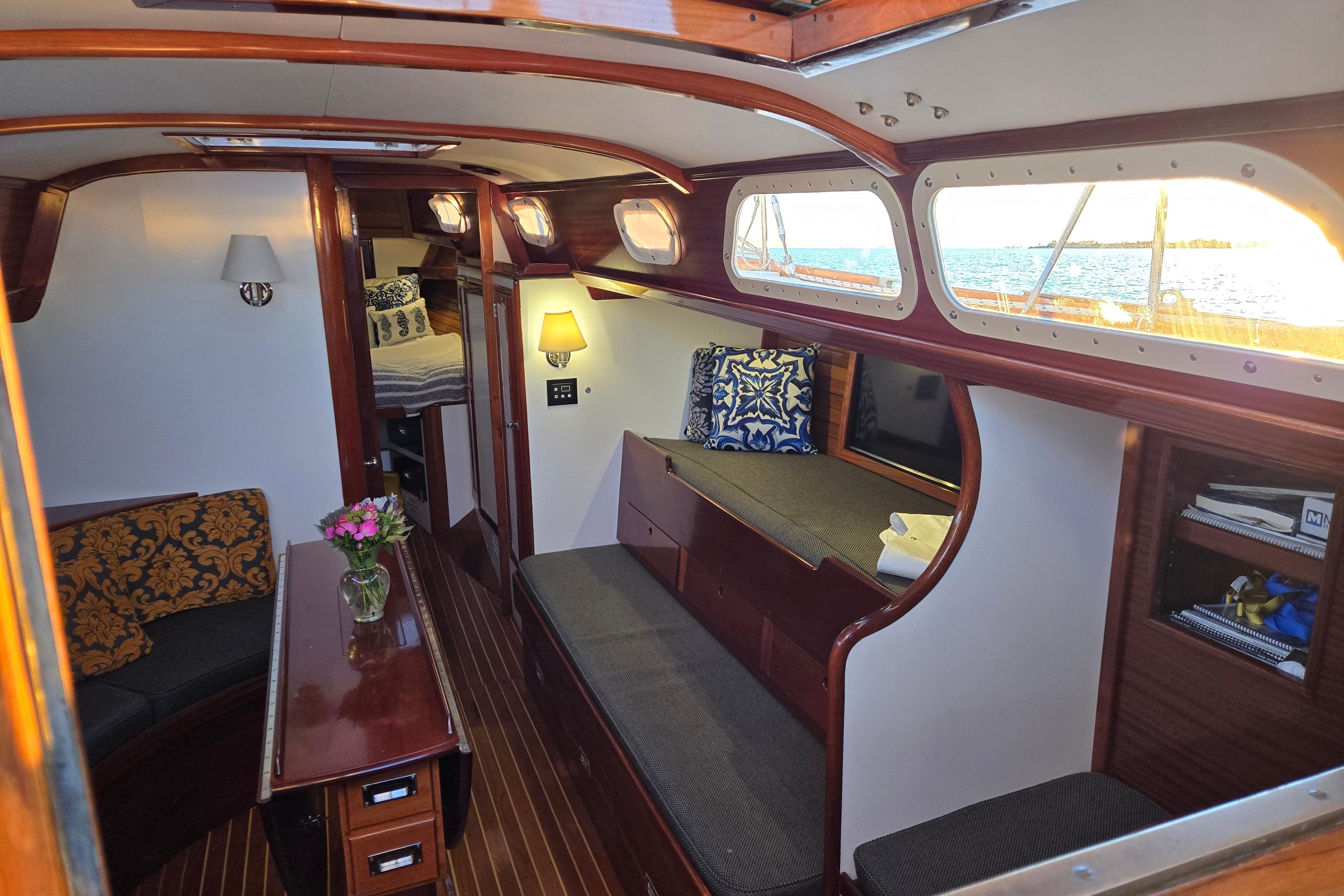 Interior of a 1970 Hinckley Bermuda 40 sailboat, featuring elegant woodwork and cozy seating.