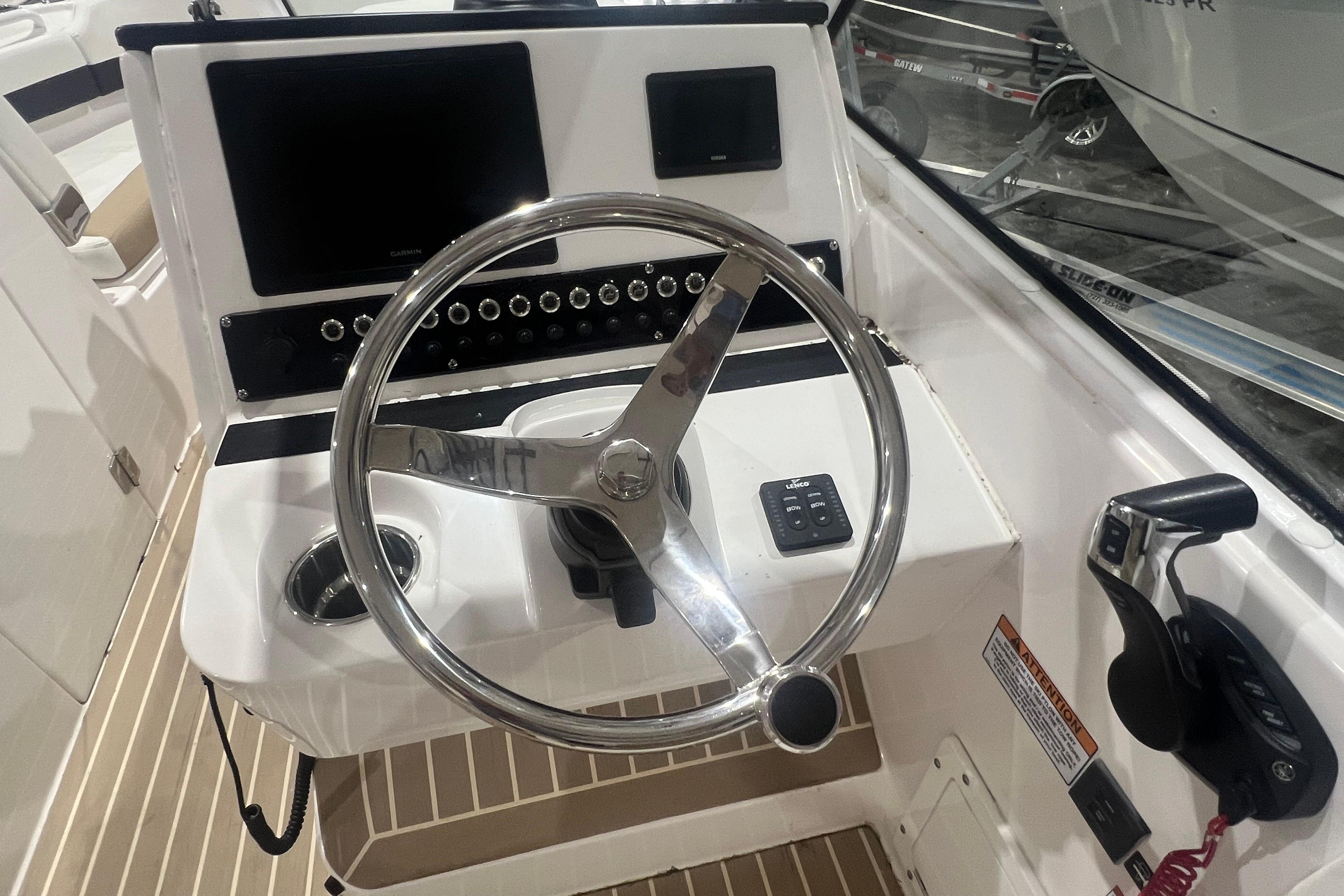 2023 Edgewater 230CX Crossover boat helm with steering wheel and control panel.