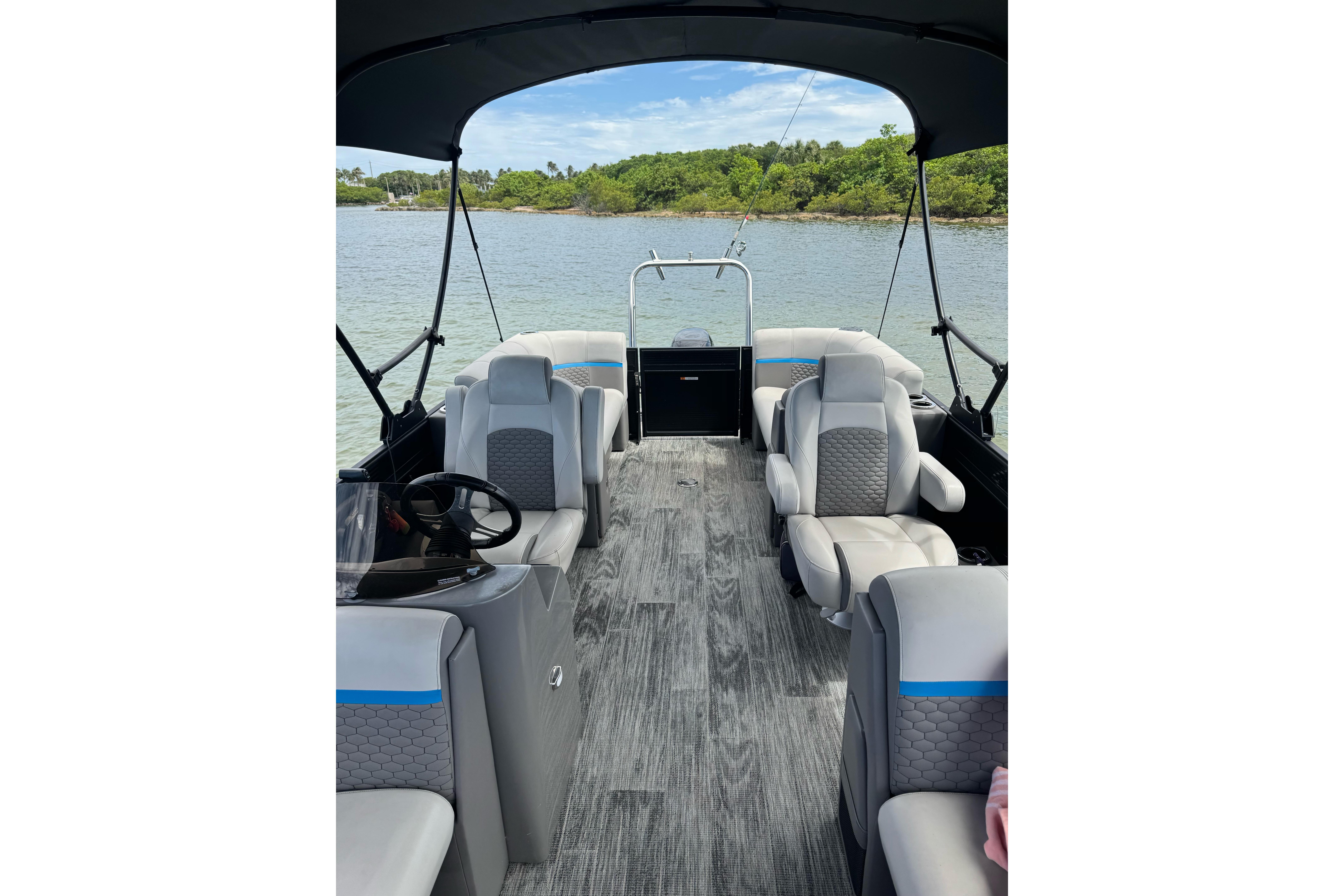 Interior view of 2022 Qwest Edge 820 CTR pontoon boat with modern seating and scenic water backdrop.