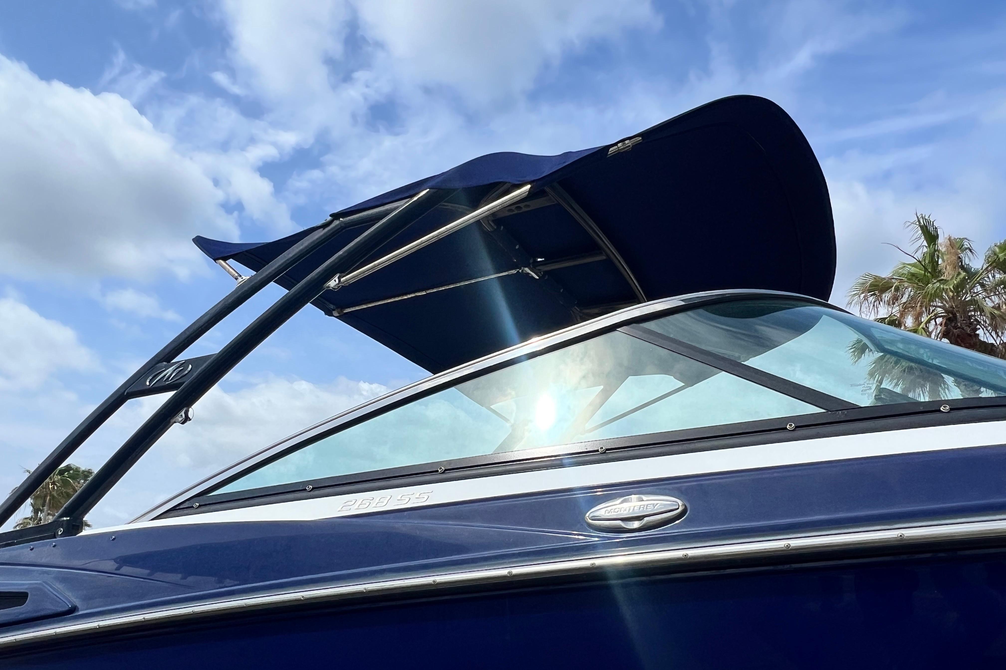 2015 Monterey 268SS Super Sport boat with blue canopy under a sunny sky.