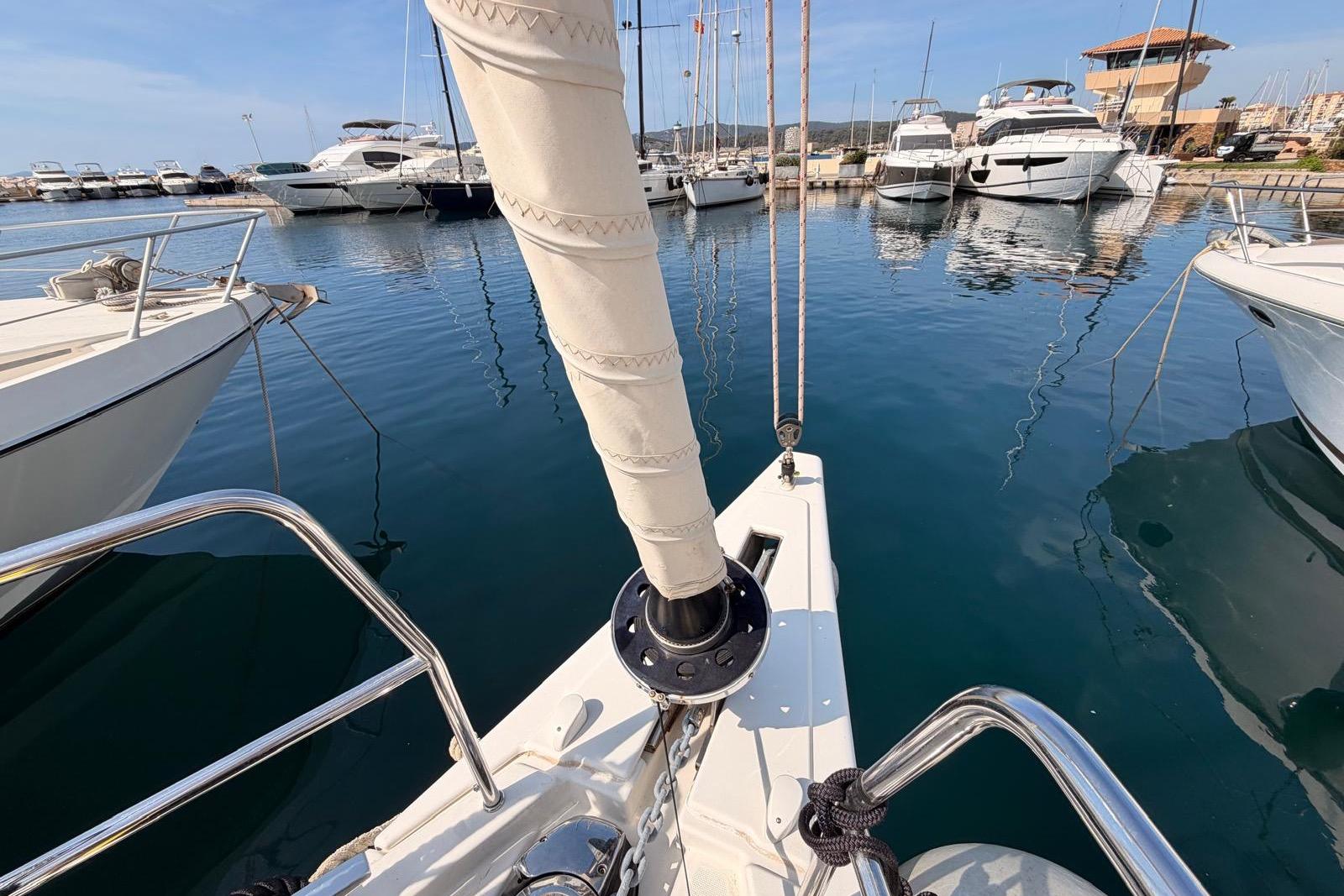 2023 Dufour 470 sailboat docked in a marina with other yachts.