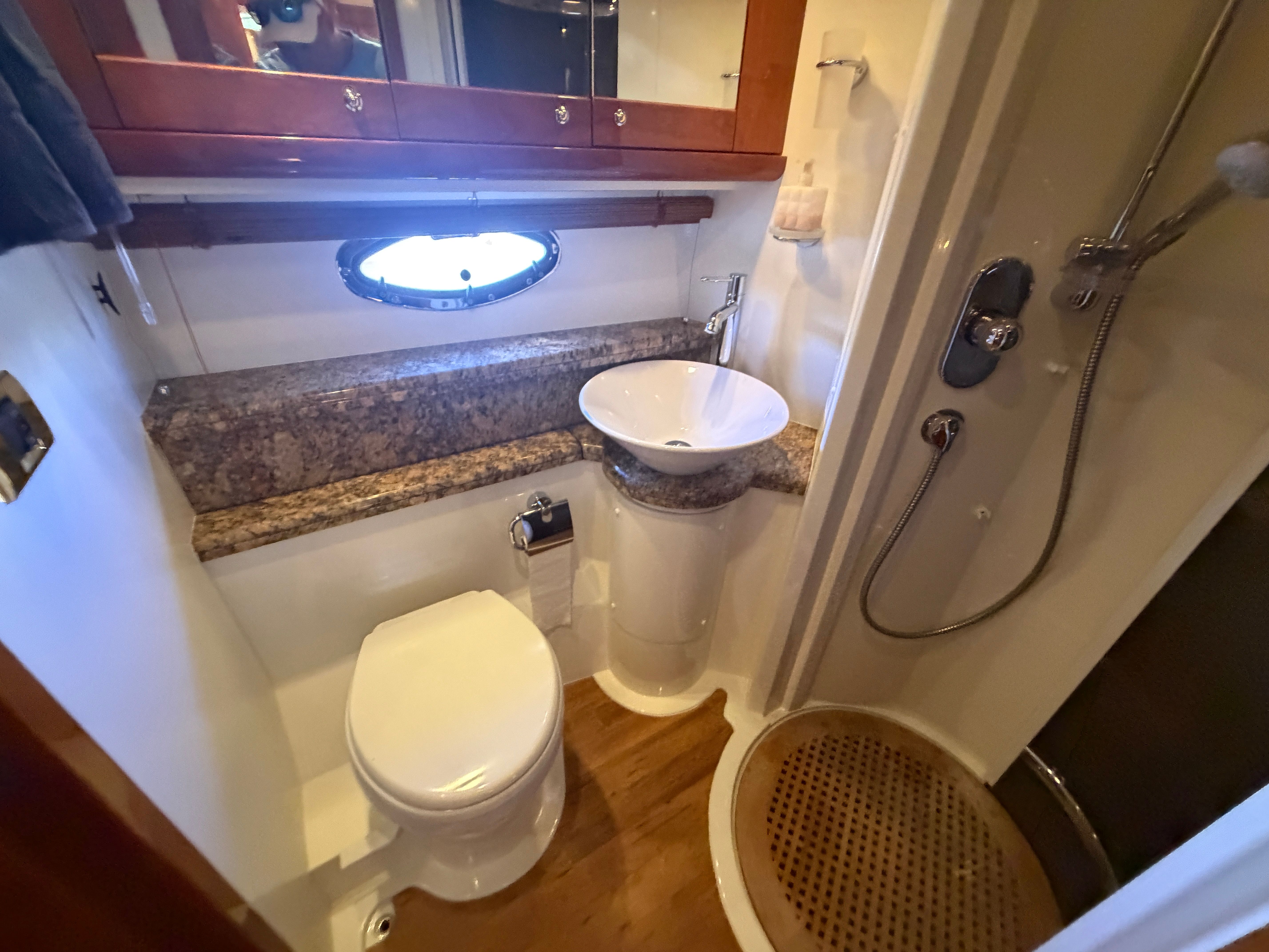 Bathroom with toilet, sink, and shower in a yacht.