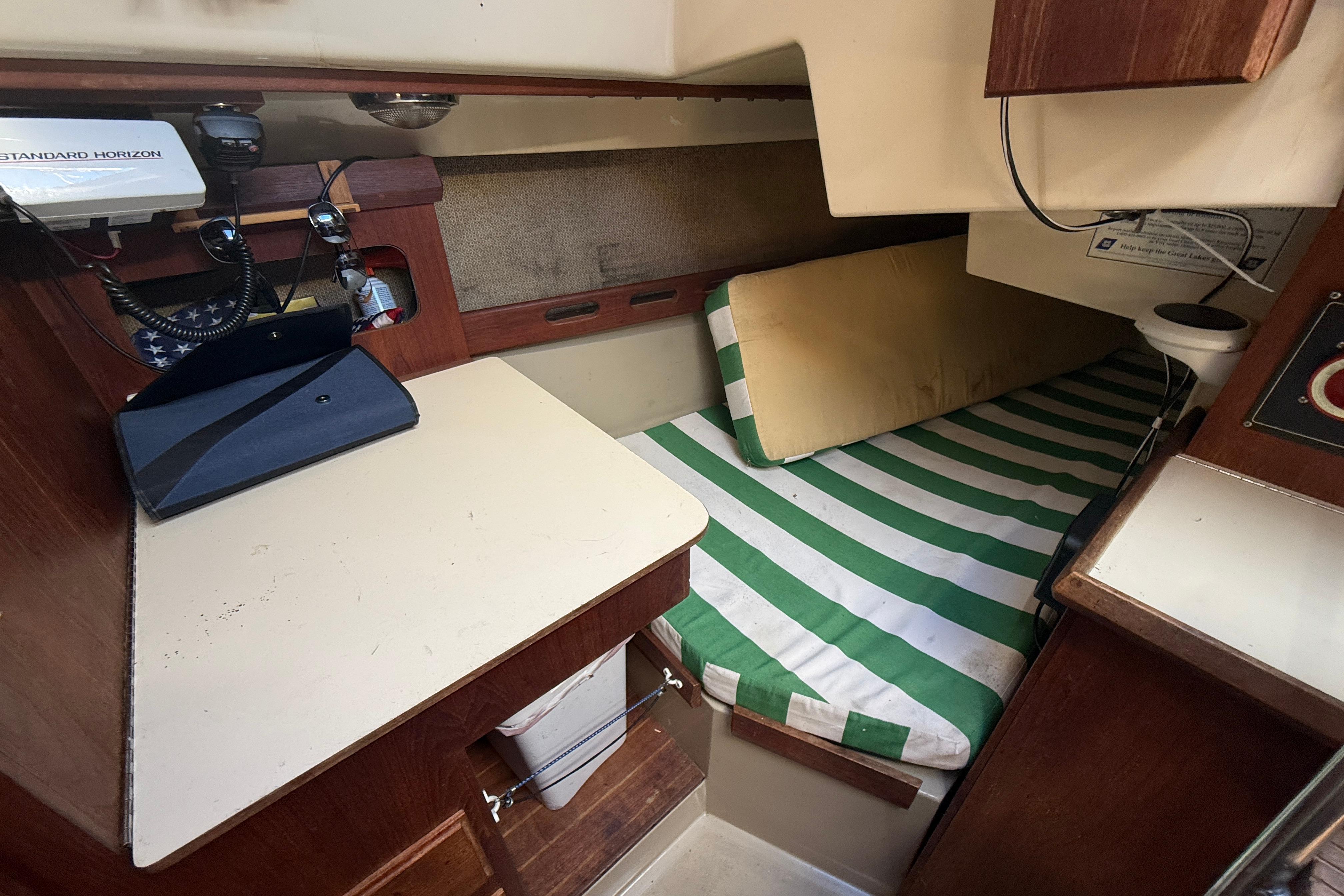 1983 O'Day 34 sailboat interior with striped bedding and navigation equipment.