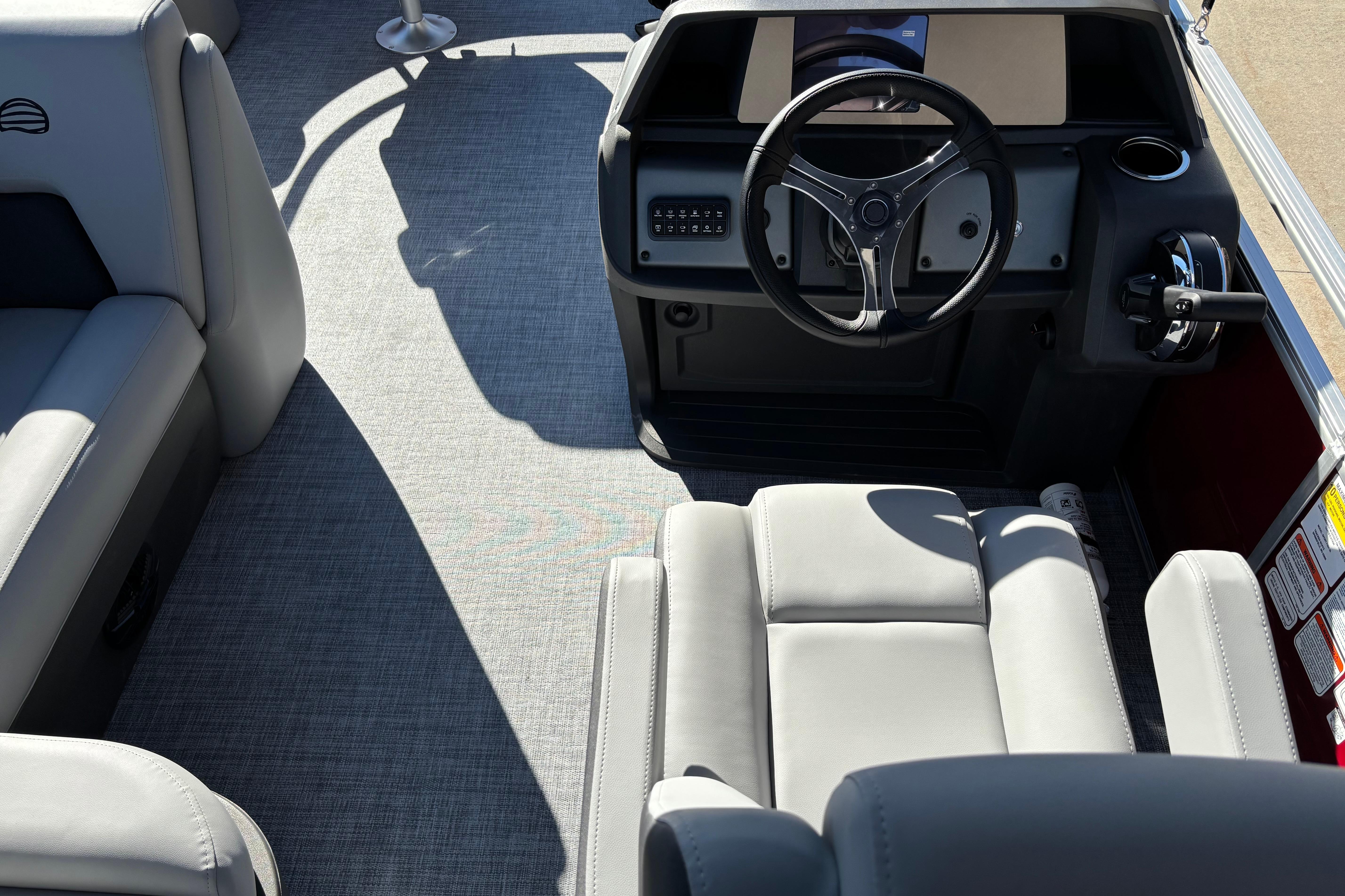 Interior of 2026 Sun Tracker SportFish 20 DLX pontoon boat with steering wheel and seating.