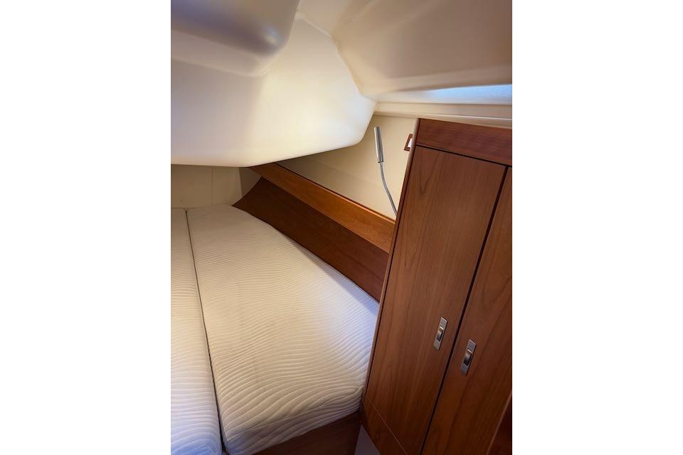 Cozy cabin interior of 2017 Dehler 38 yacht with wooden cabinetry and bed.
