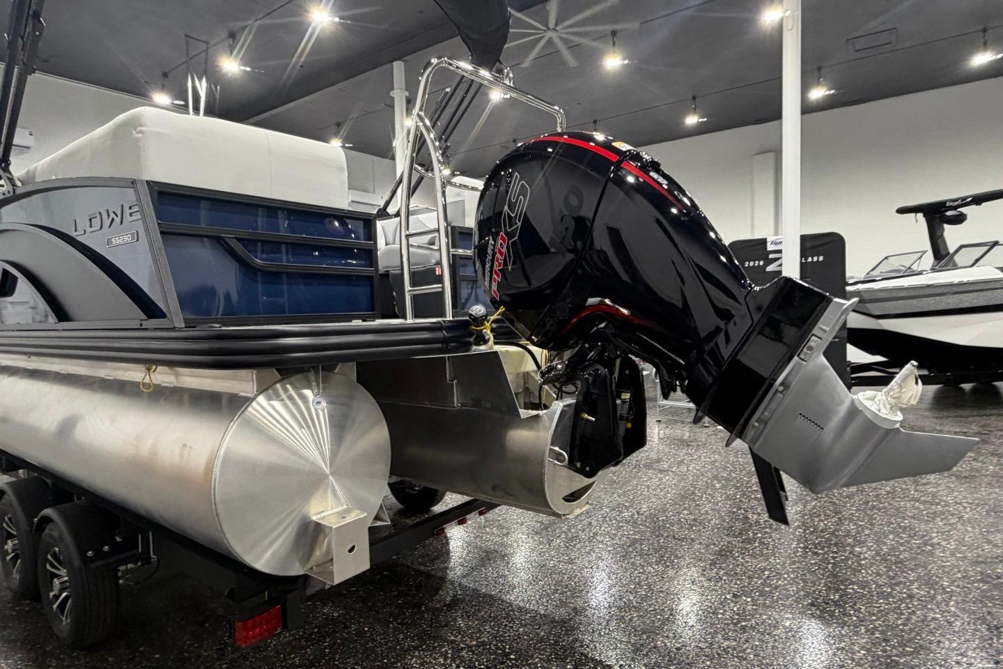 2026 Lowe SS 230 WT pontoon boat with powerful outboard motor in showroom.