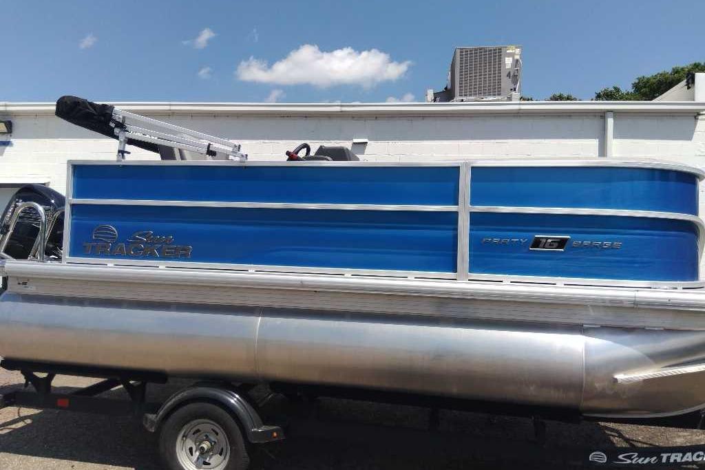 2026 Sun Tracker Party Barge 16 DLX pontoon boat with blue exterior on trailer.