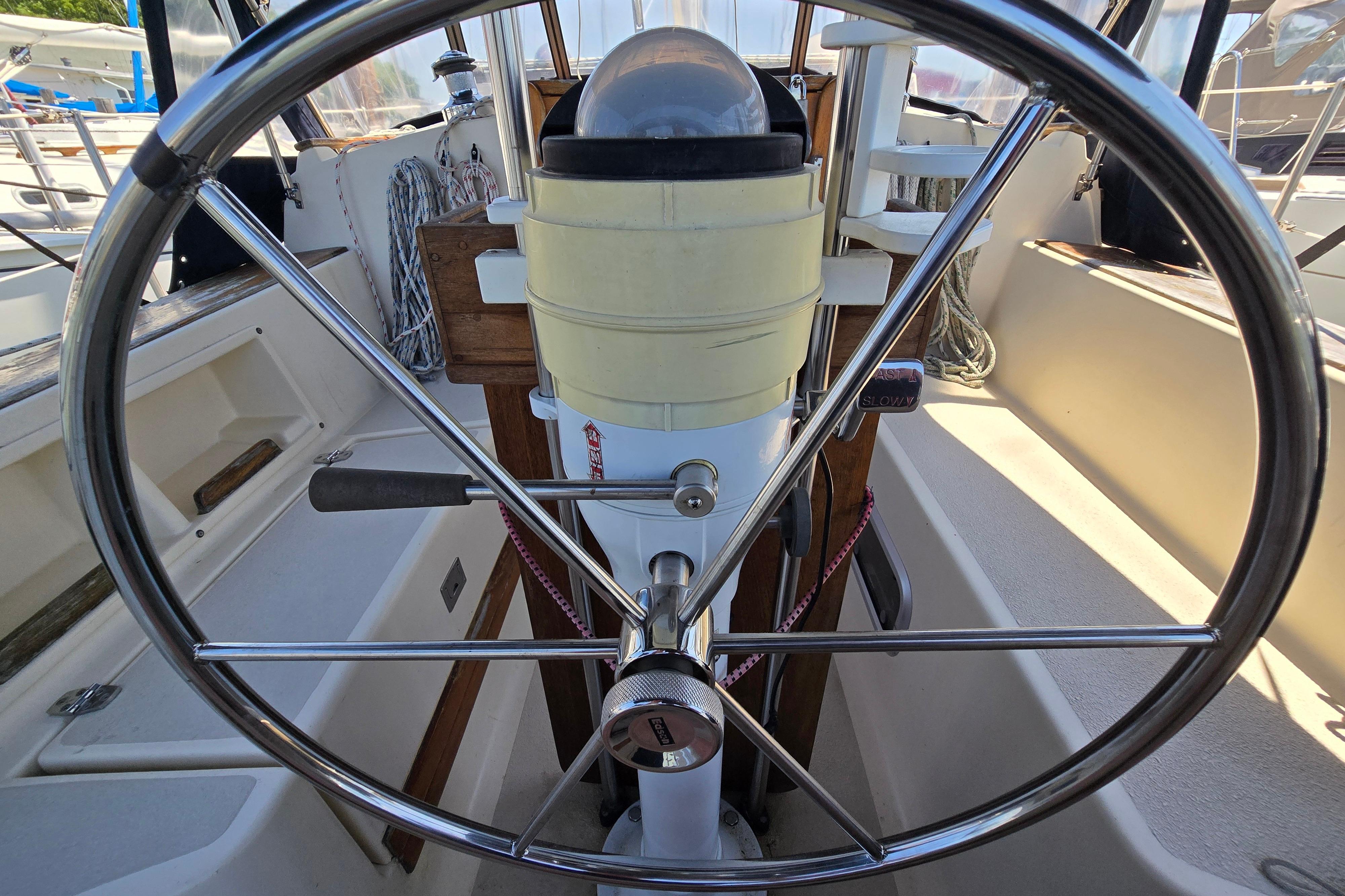 Steering wheel of a 1993 Caliber 35 sailboat, showcasing nautical controls and equipment.