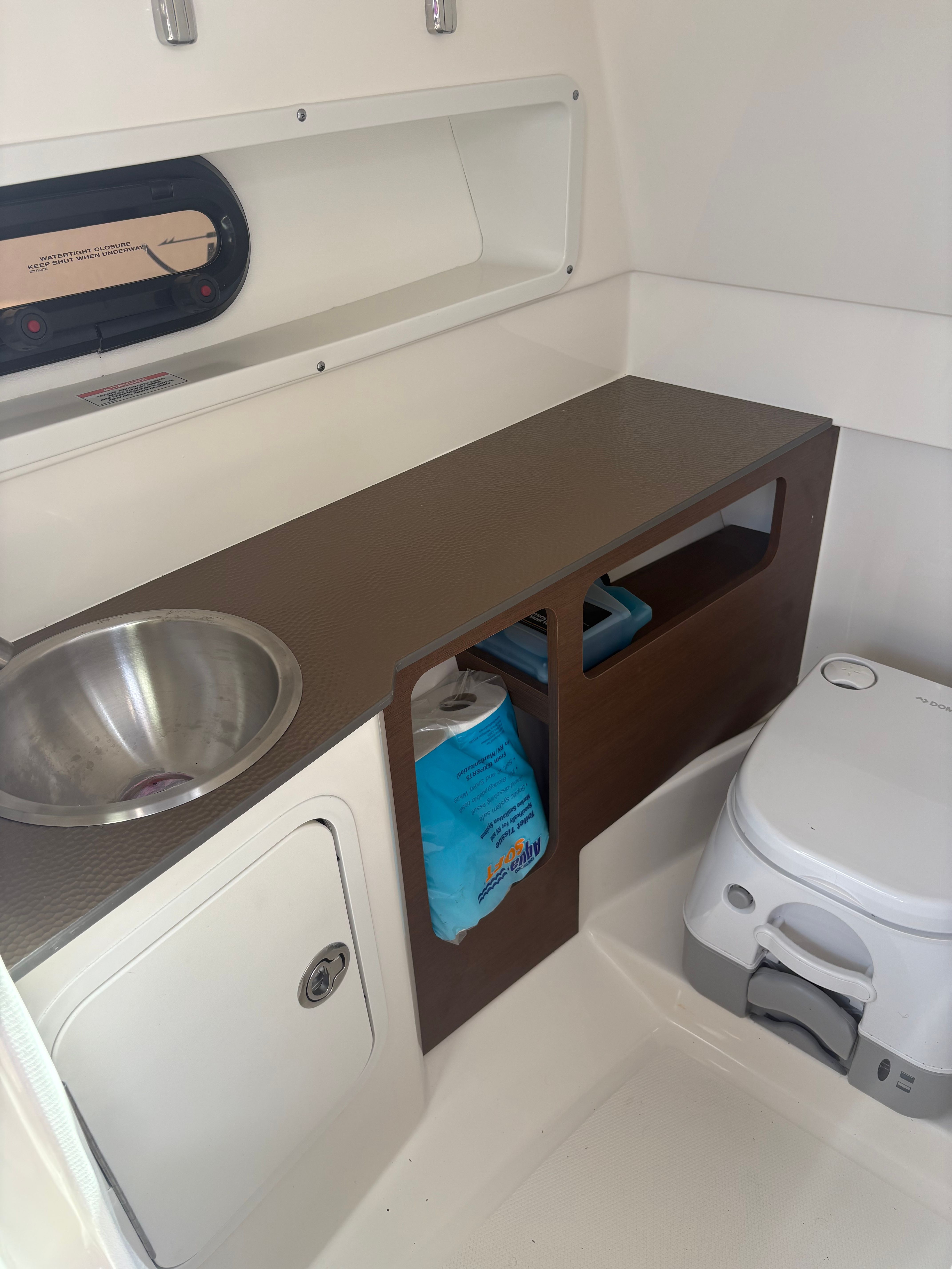 Interior of a Sea Ray SDX 270 Outboard with a sink and toilet.