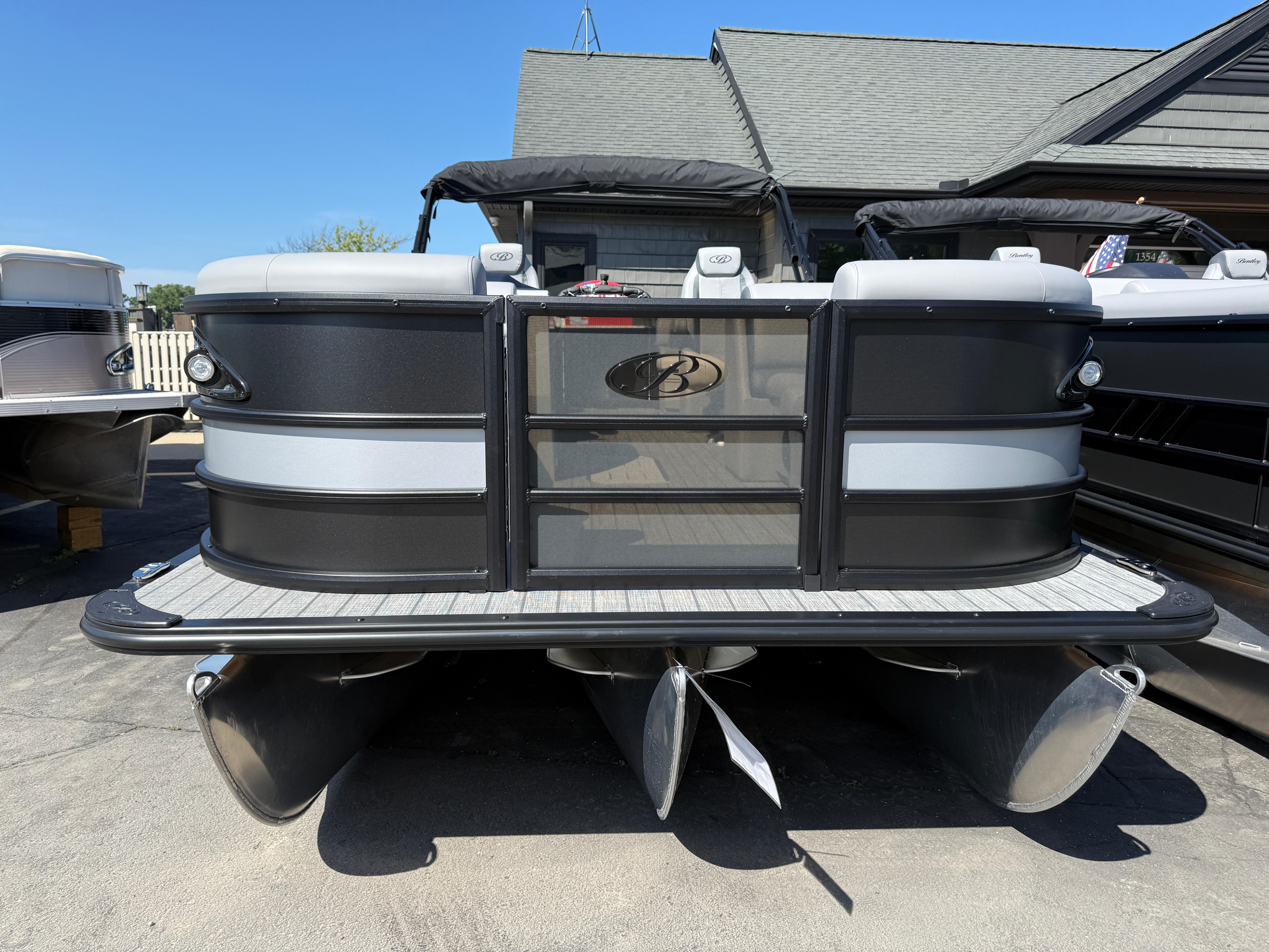 2026 Bentley Pontoons Legacy 223 Navigator, sleek black and gray design, docked outdoors.