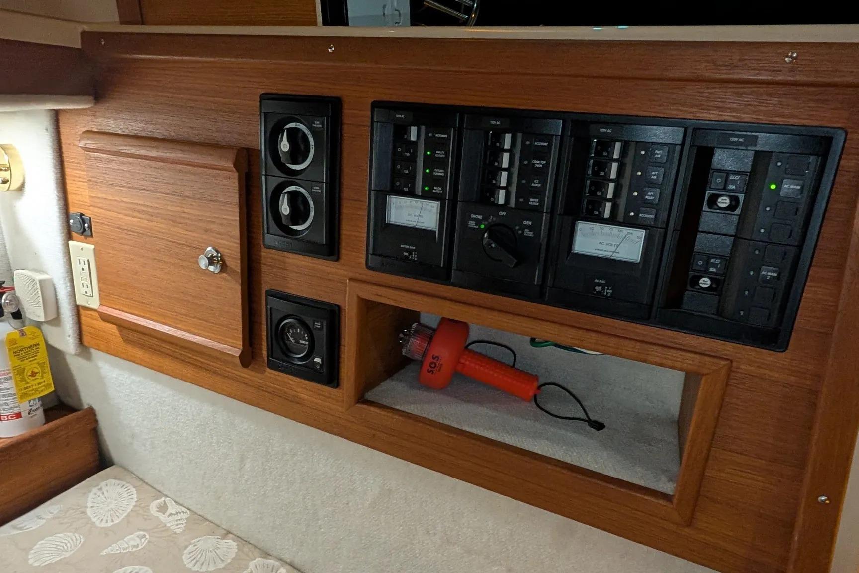 Control panel of a 2015 Ranger Tugs R-29 S boat with electrical switches and storage.