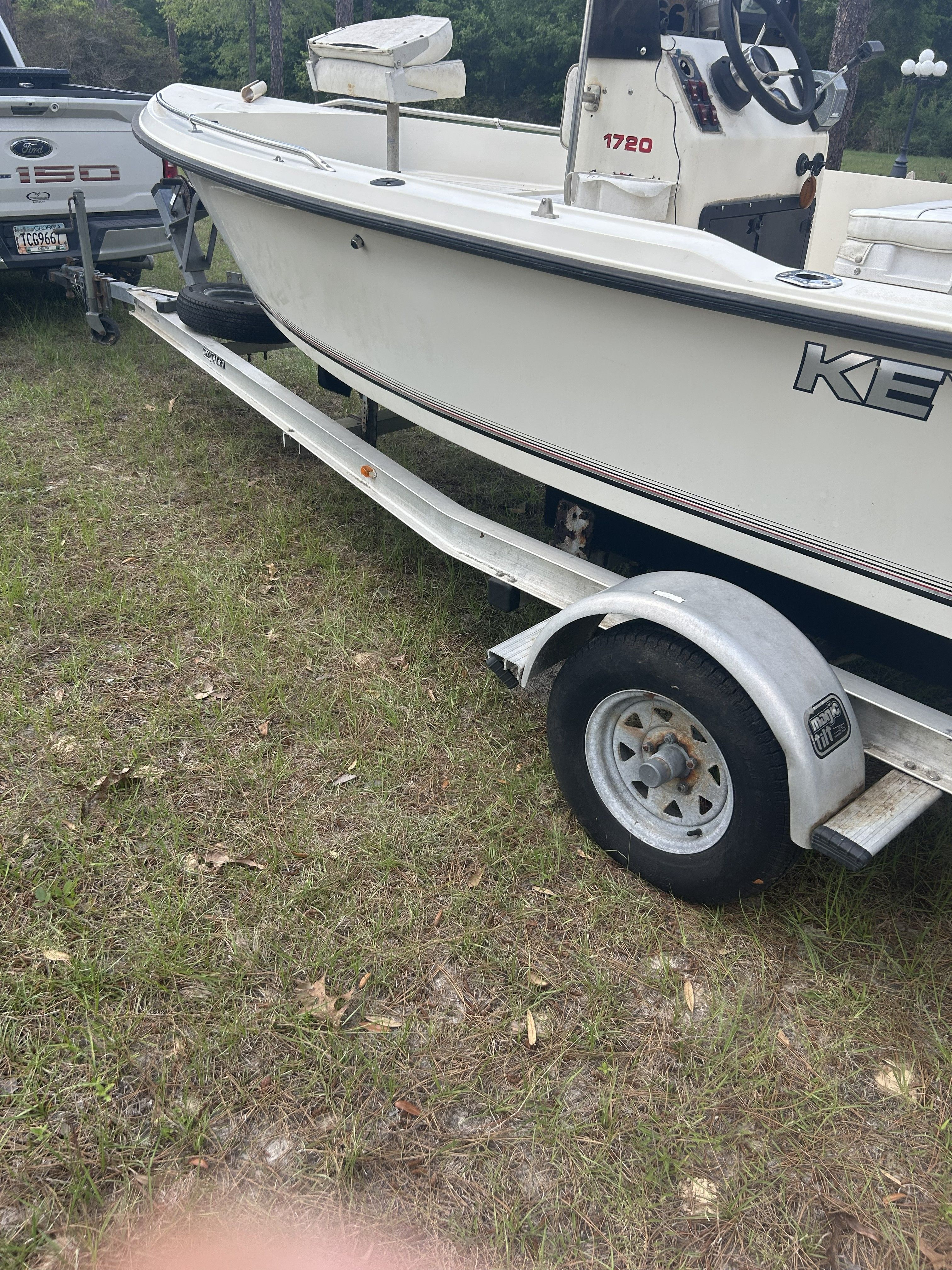 1993 Key West 1720 boat on trailer parked outdoors.
