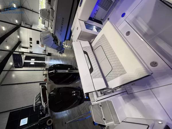 2025 Blackfin 272CC boat interior with modern seating and storage in a showroom.
