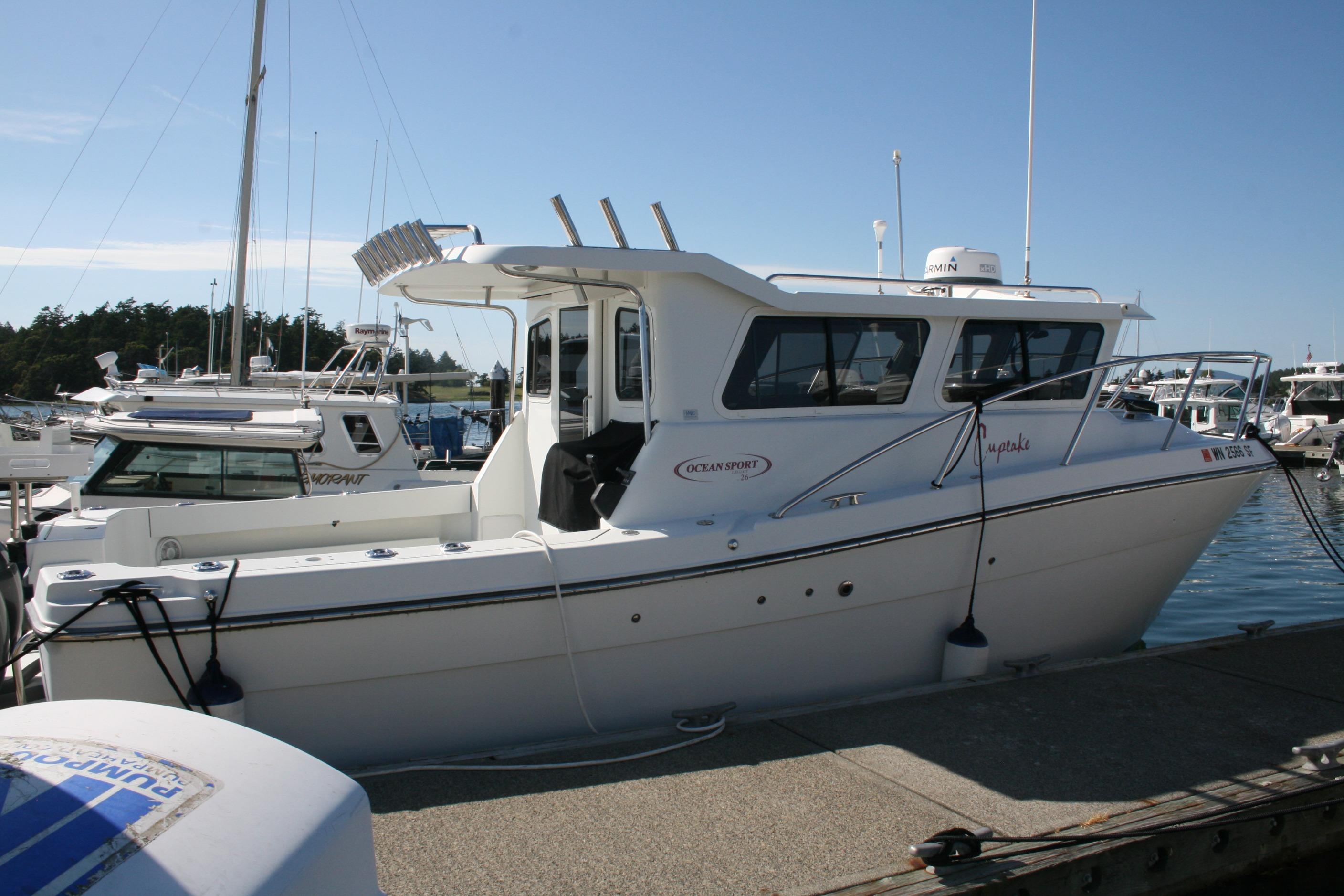 2014 Ocean Sport 27' Legacy boat docked at marina under clear blue sky.