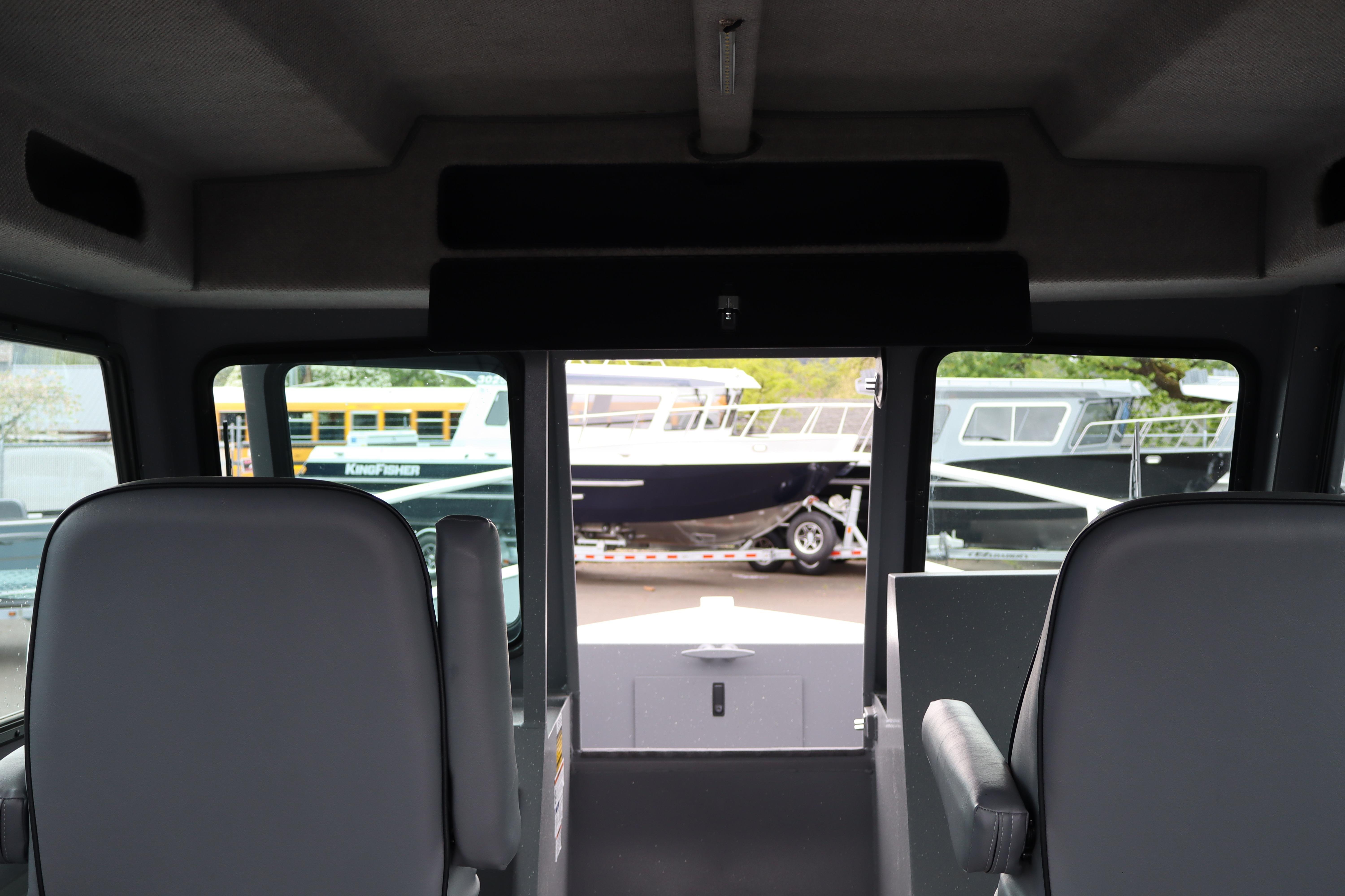 Interior view of 2026 Alumaweld Horizon 24 boat with exterior boats visible through windows.