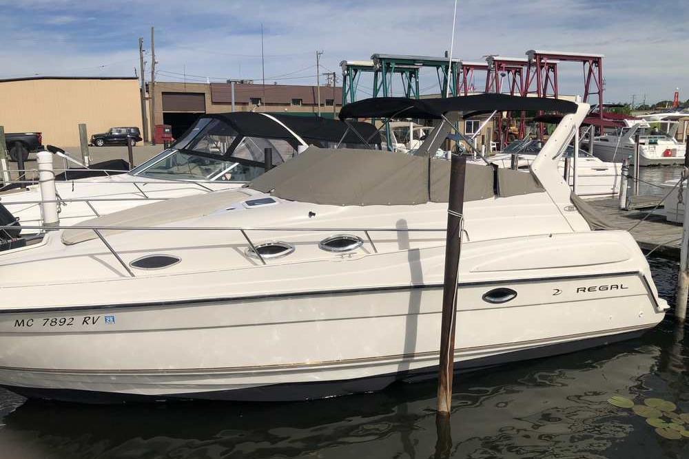 1999 Regal Commodore 2760 boat docked at marina, featuring sleek white design.