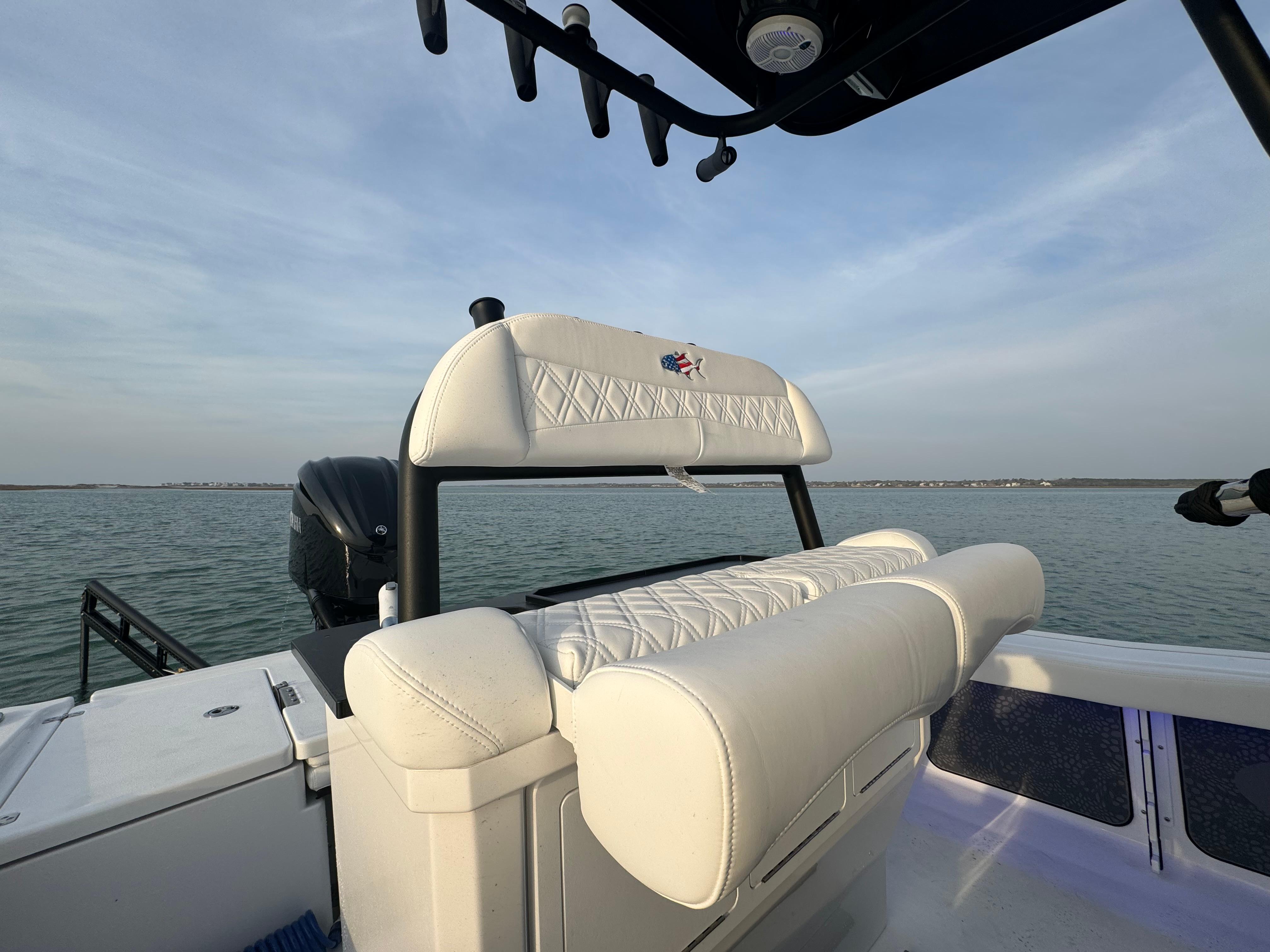 2025 Crevalle 24 HCO boat with white seating, on calm water.
