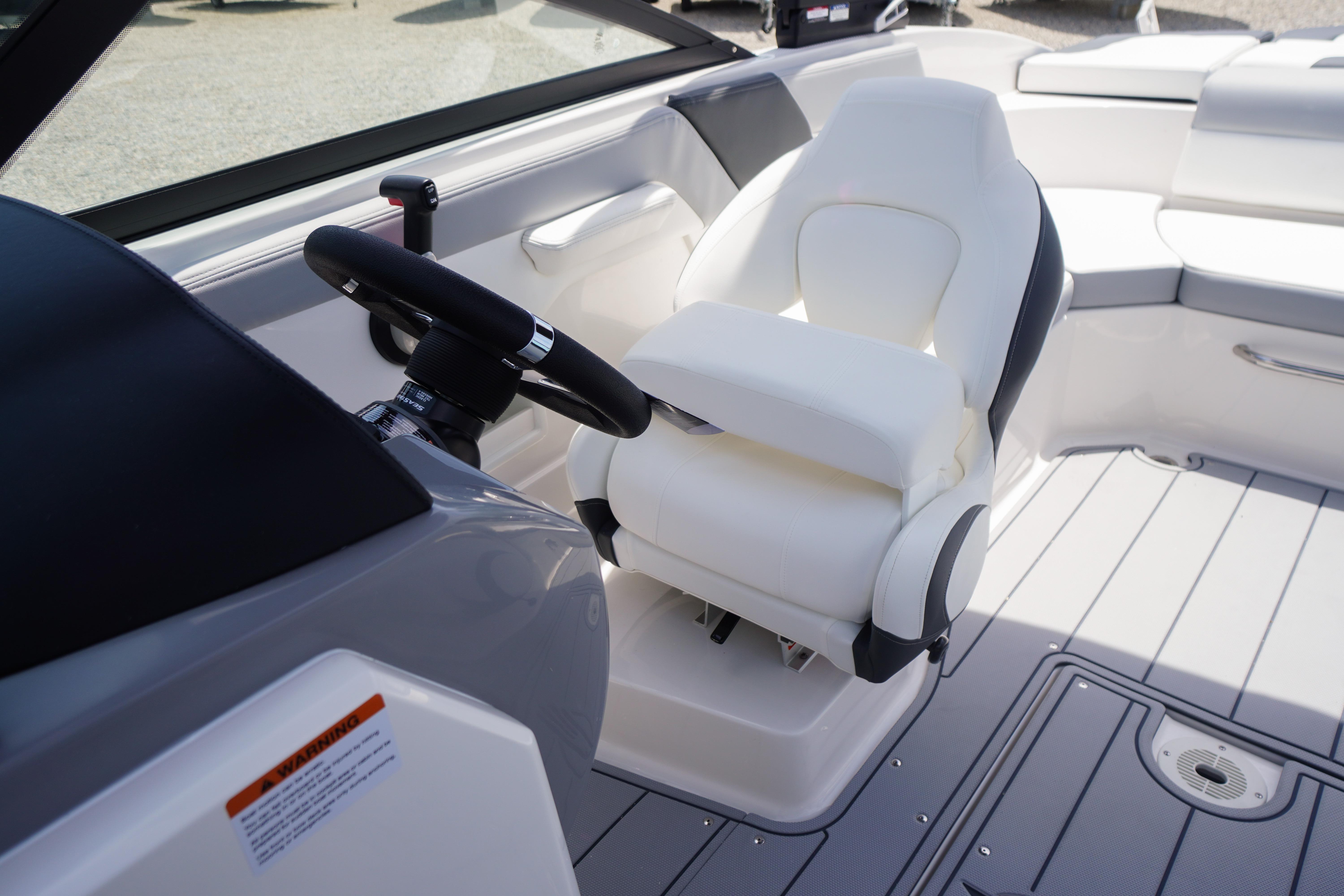 2026 Chaparral 23 SSi OB boat interior with white captain's chair and steering wheel.