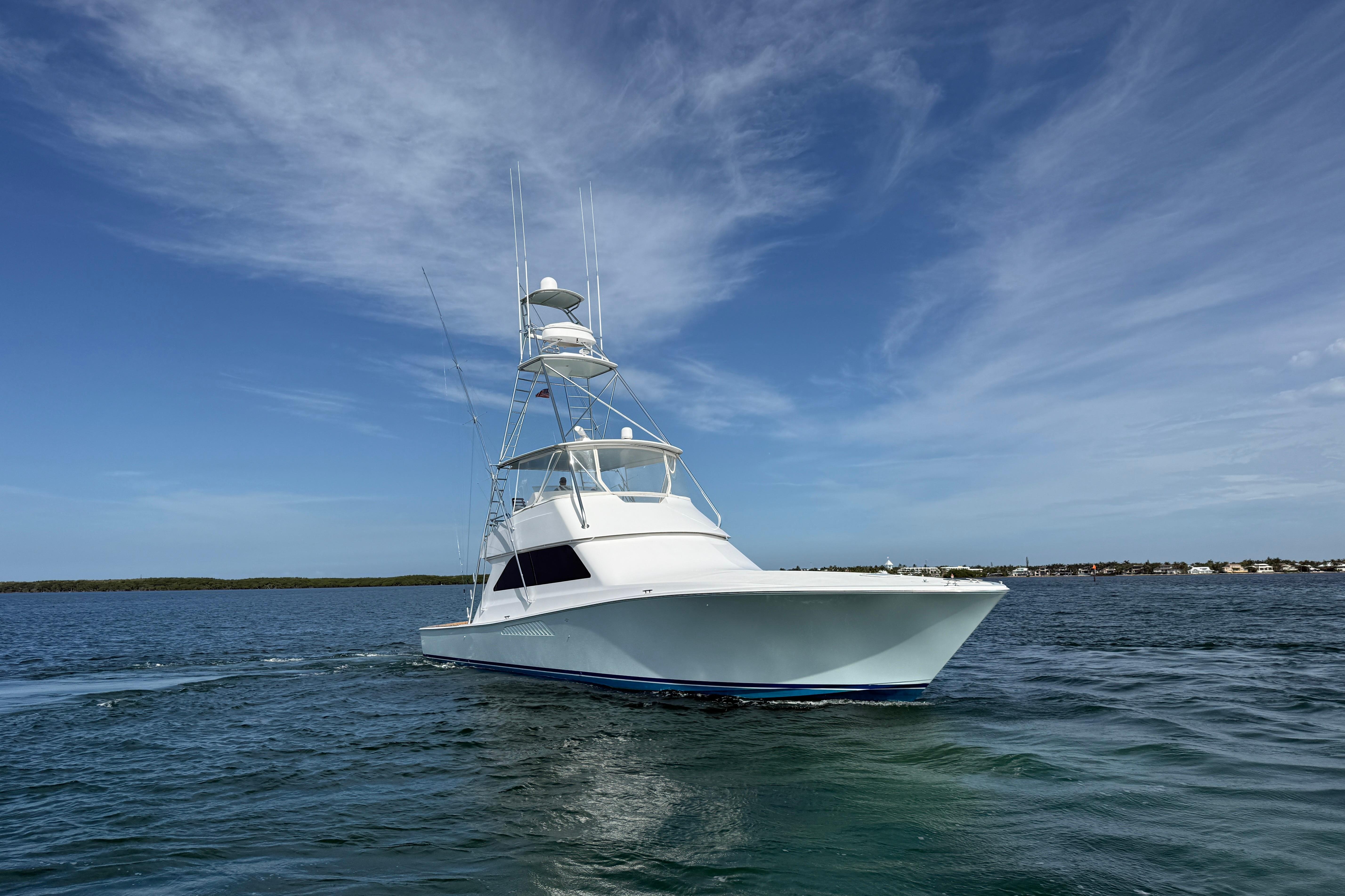 Viking 55 Convertible yacht from 2000 cruising on open water under a clear blue sky.