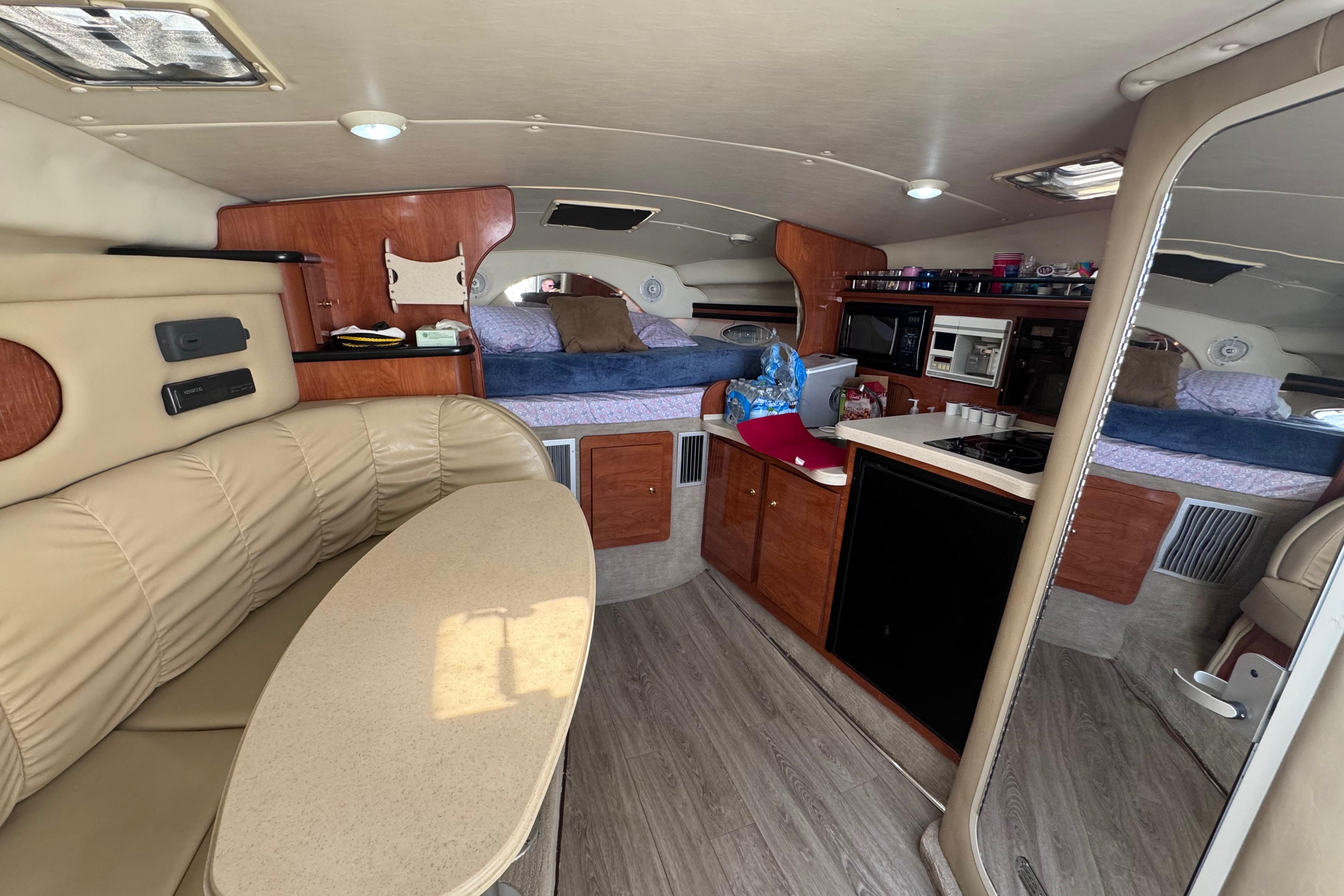 Interior of a 2003 Rinker Fiesta Vee 312 boat with cozy seating and kitchenette.