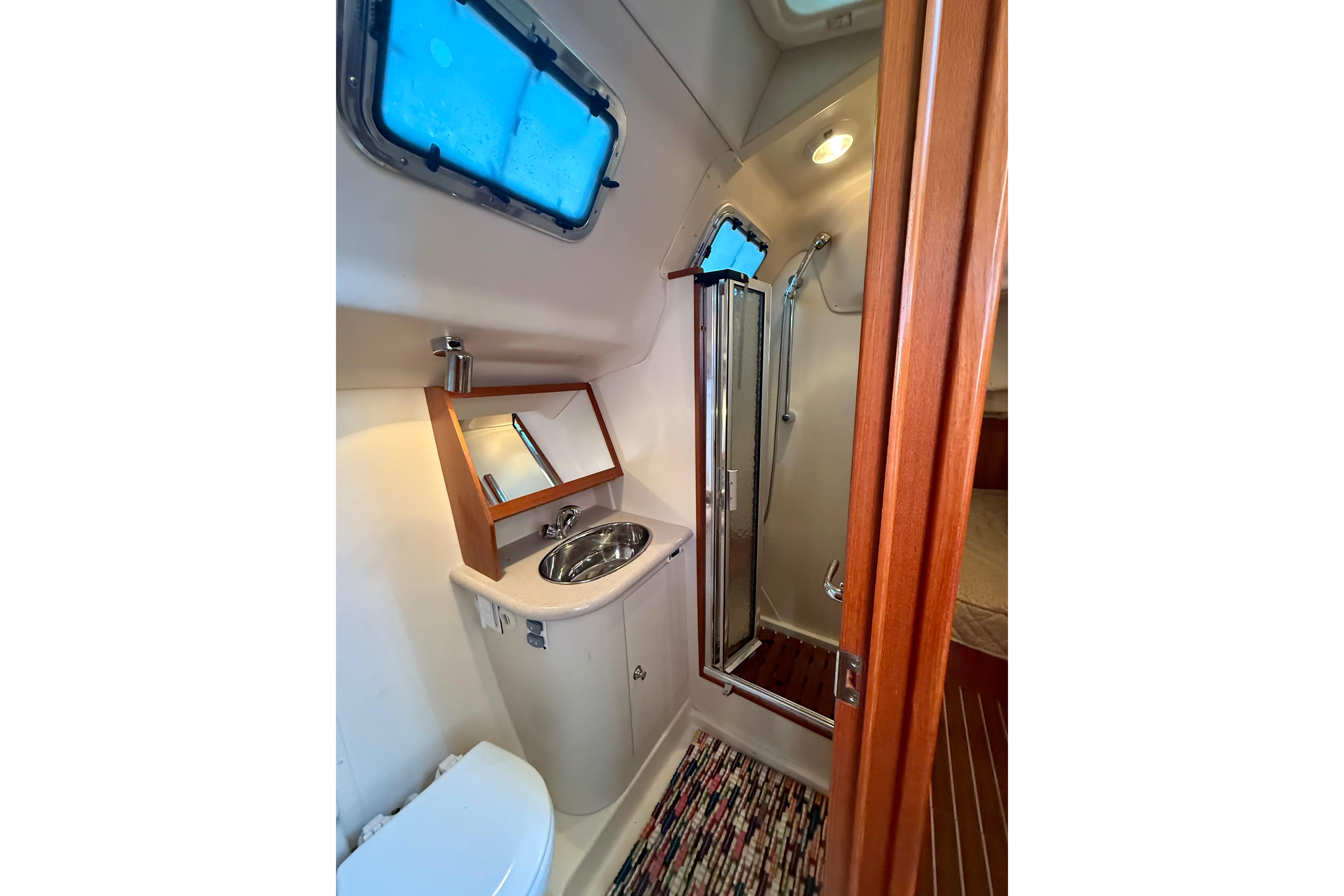 Bathroom interior of 2007 Hunter 41 Deck Salon yacht with sink, mirror, and shower.