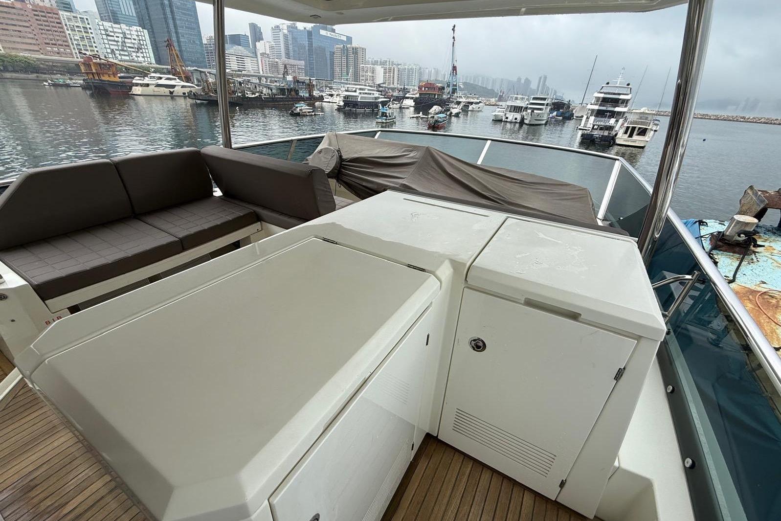 Luxury yacht deck with seating, overlooking marina; Prestige 630, 2019 model.