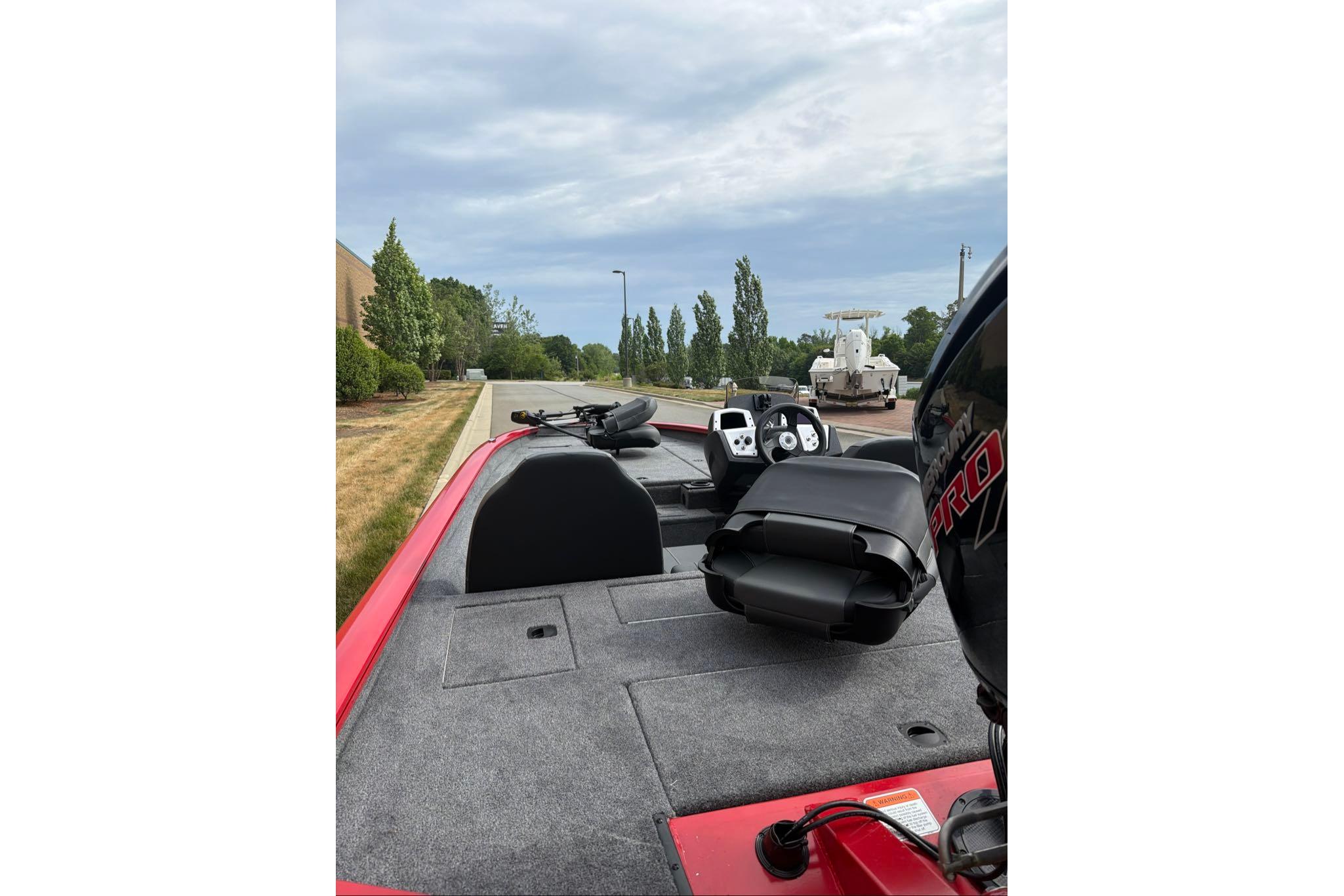 2026 Tracker Pro Team 190 boat interior with steering console and seating, parked outdoors.