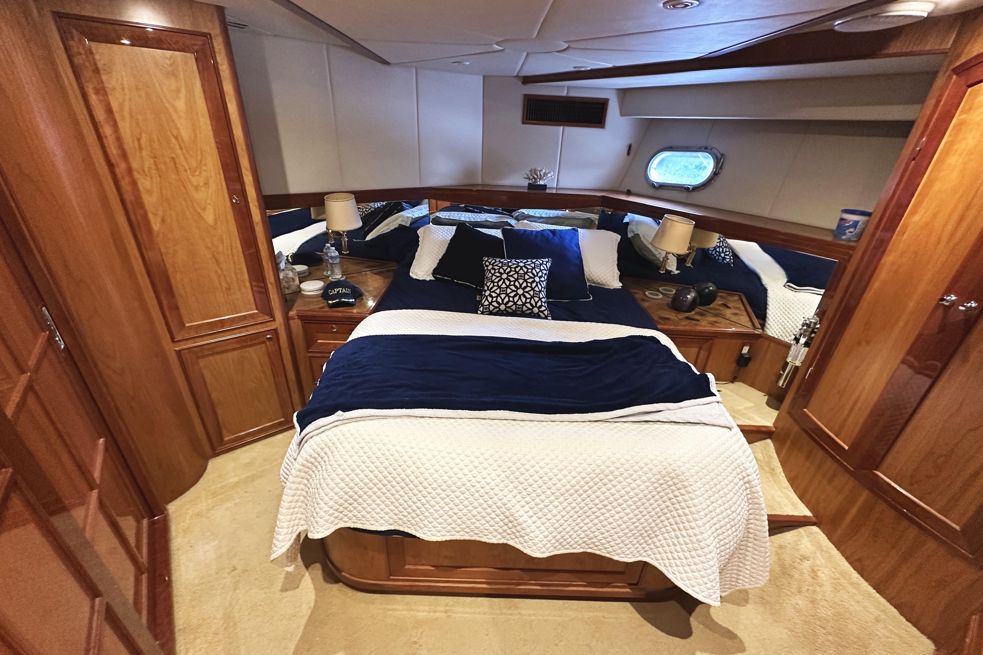 Luxurious cabin interior of 2004 McKinna 57 PHMY yacht with elegant bedding and wood finishes.