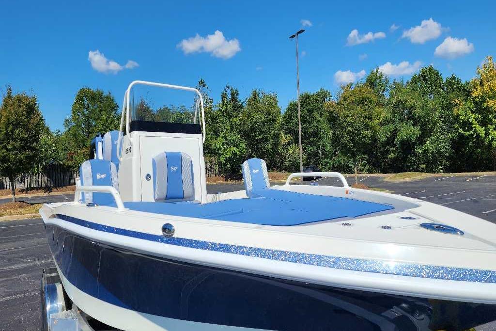 2025 Ranger 2510 Bay boat with blue seating, parked outdoors under a clear sky.