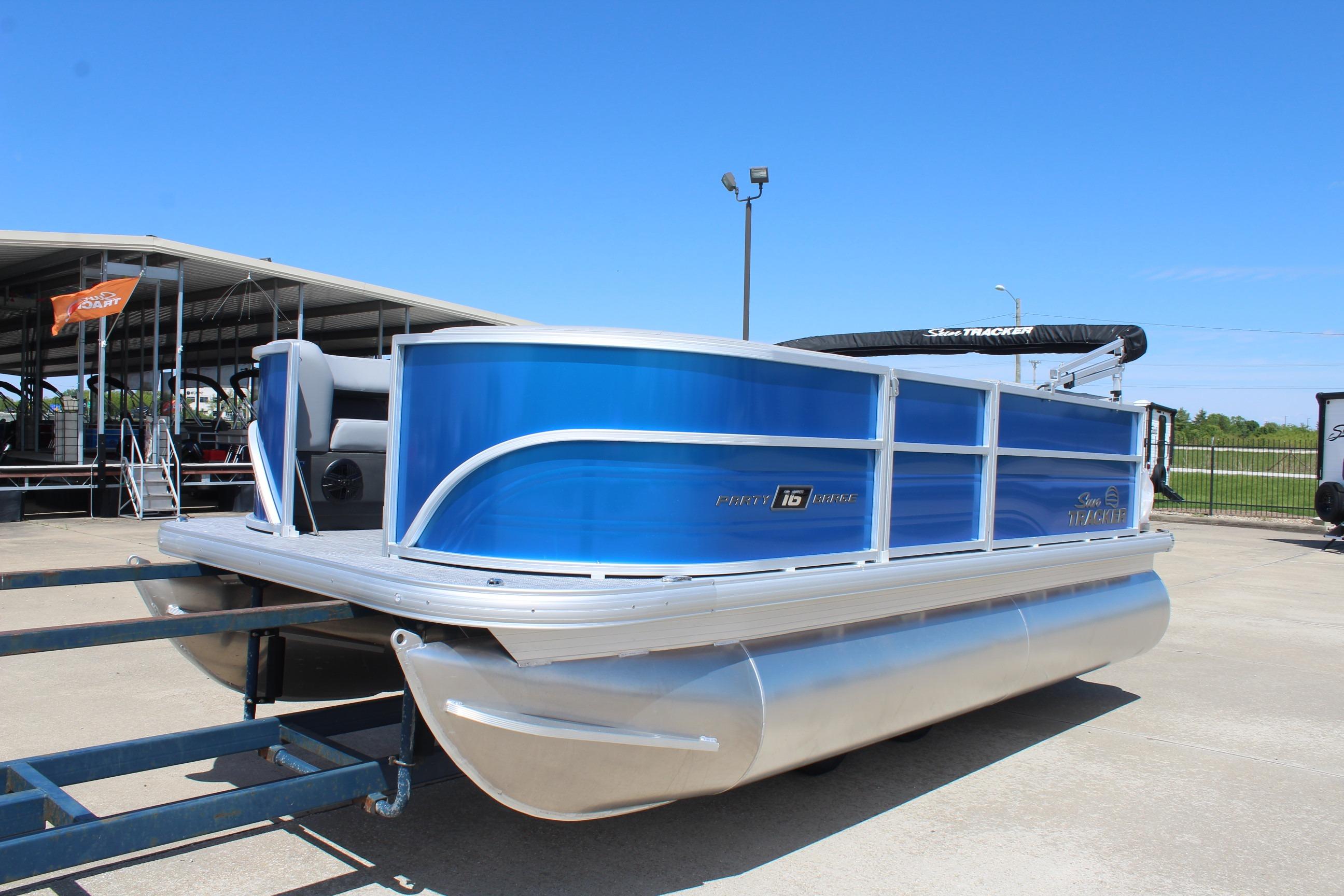 2026 Sun Tracker Party Barge 16 DLX pontoon boat on trailer, blue exterior.