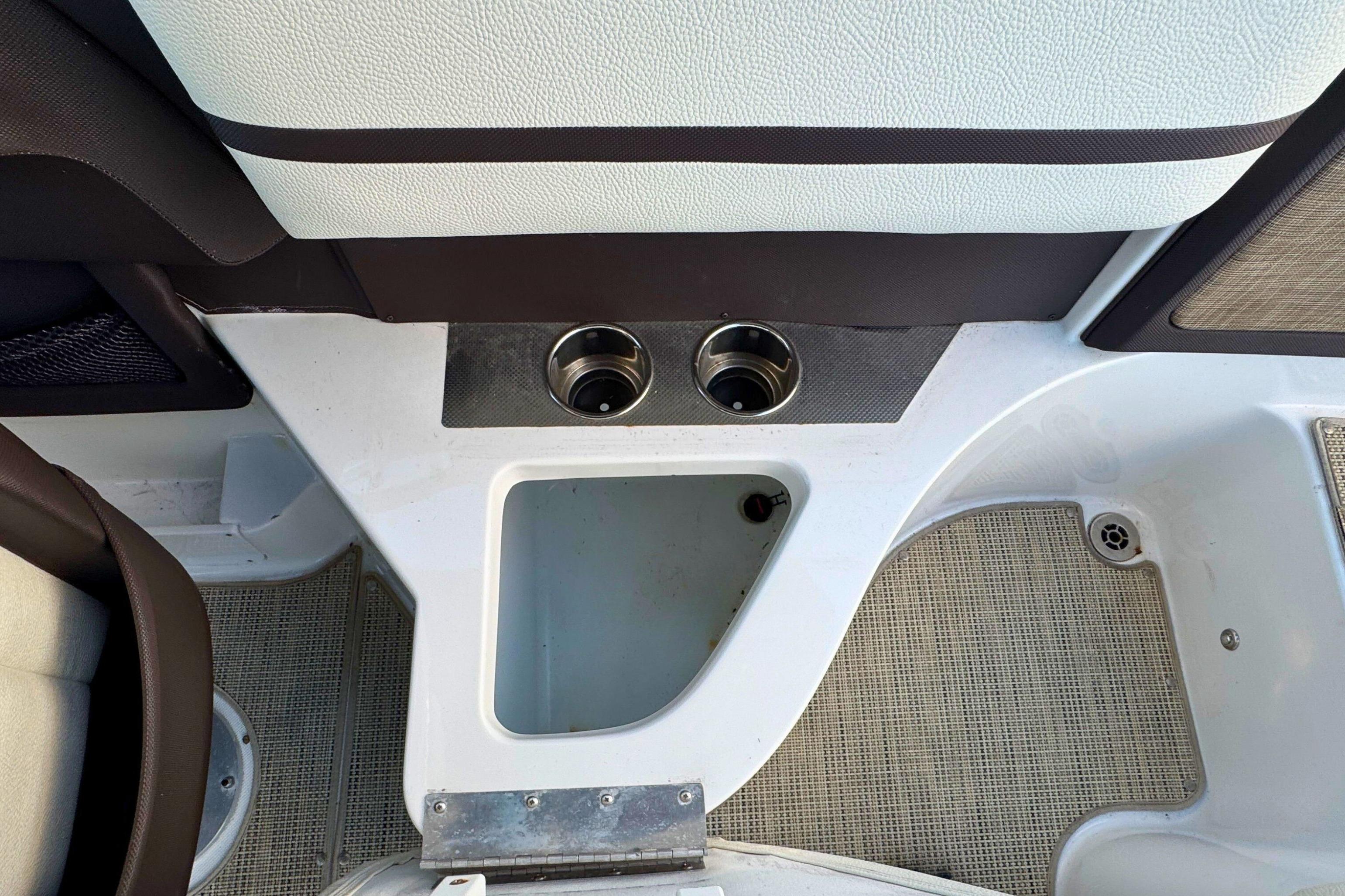 Interior of a 2019 Cobalt R3 boat showing cup holders and storage compartment.