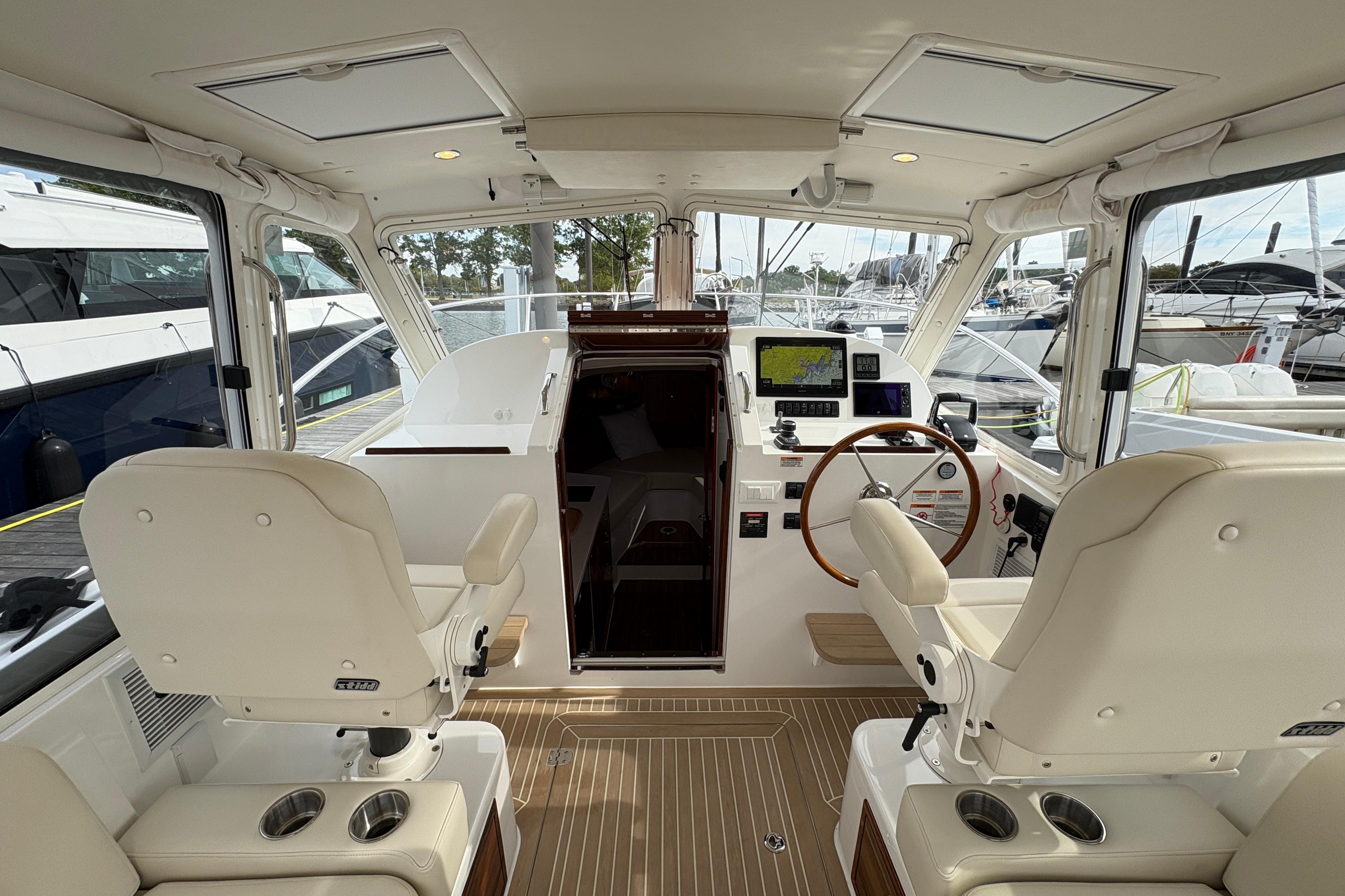 Interior of 2023 MJM 35 yacht, featuring helm station and luxurious seating.