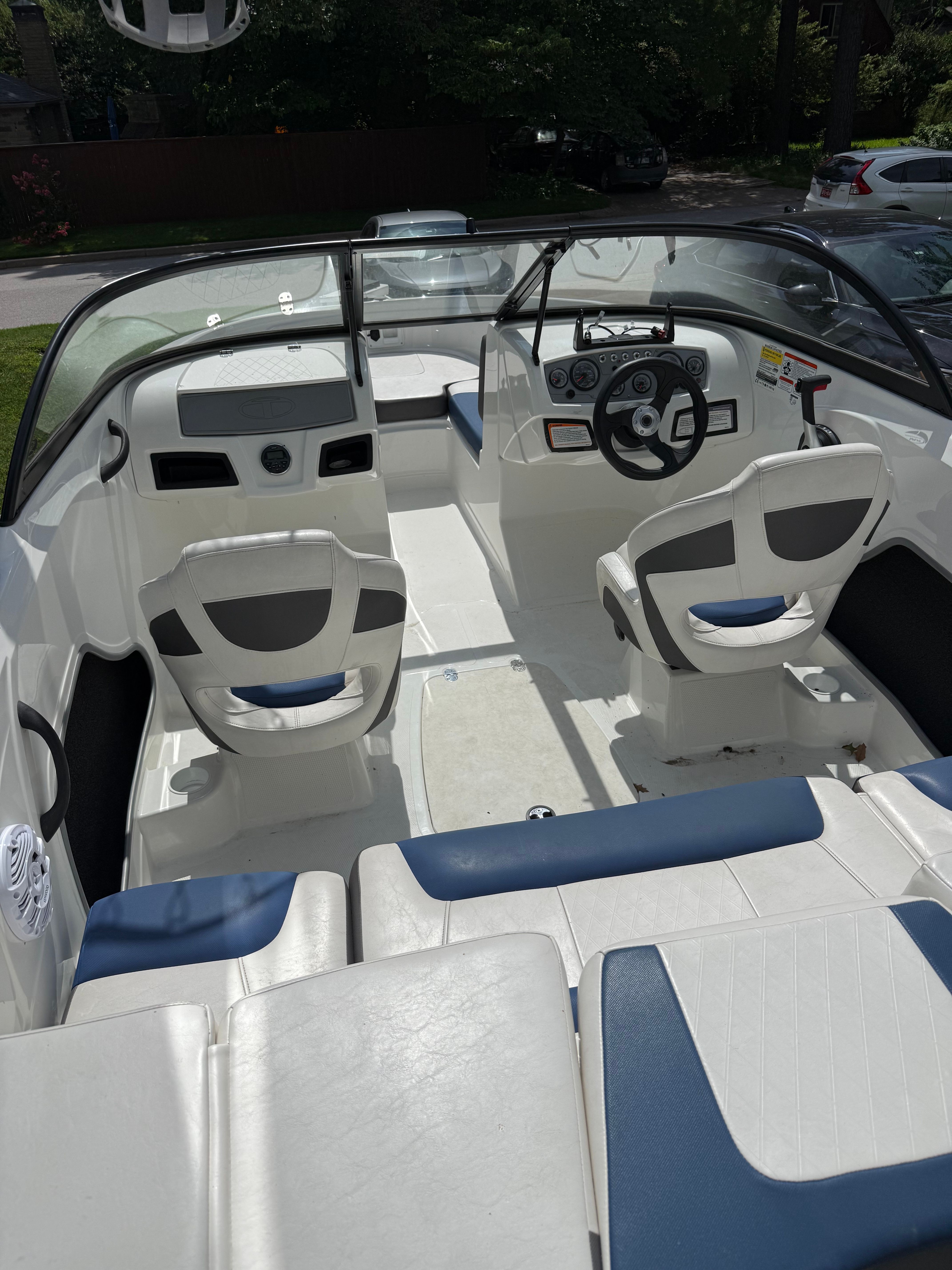 Interior view of a 2019 Tahoe 450 TF with white and blue seating and a helm station.