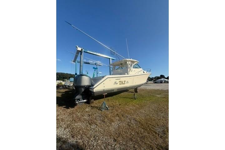 2010 Pursuit OS 375 Offshore boat on dry dock under clear blue sky.