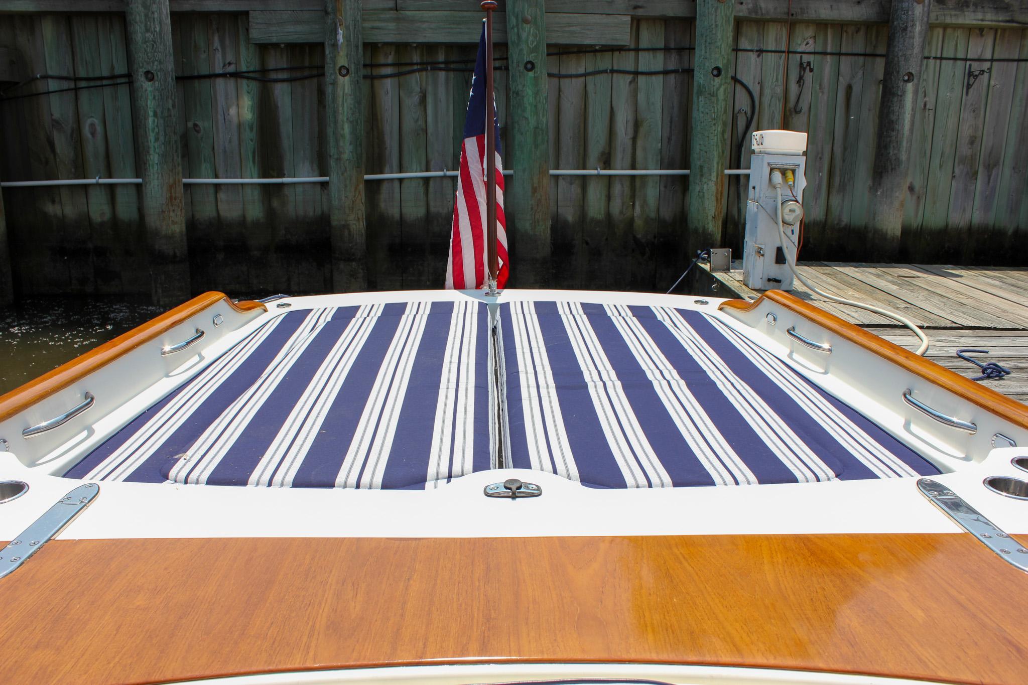 2008 Hinckley Talaria 38R Convertible boat with striped deck cushions and American flag.