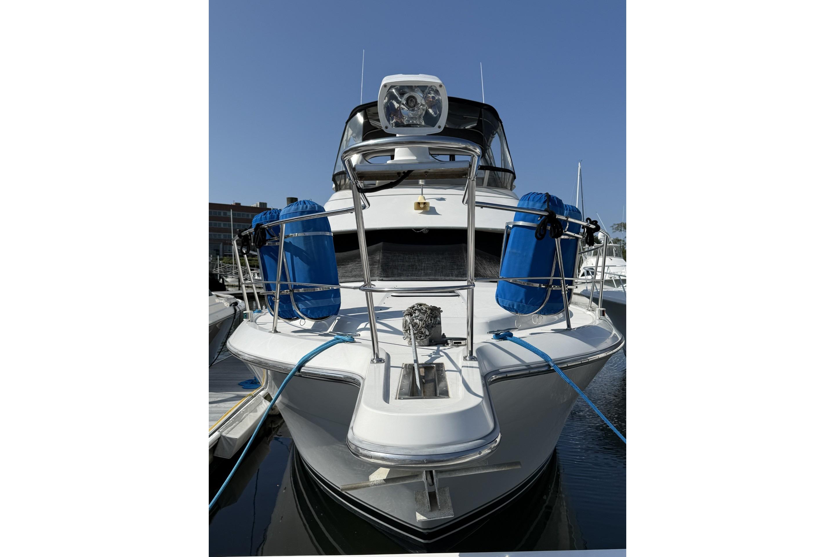 1993 Carver 350 Motor Yacht docked, front view with blue fenders, clear sky background.