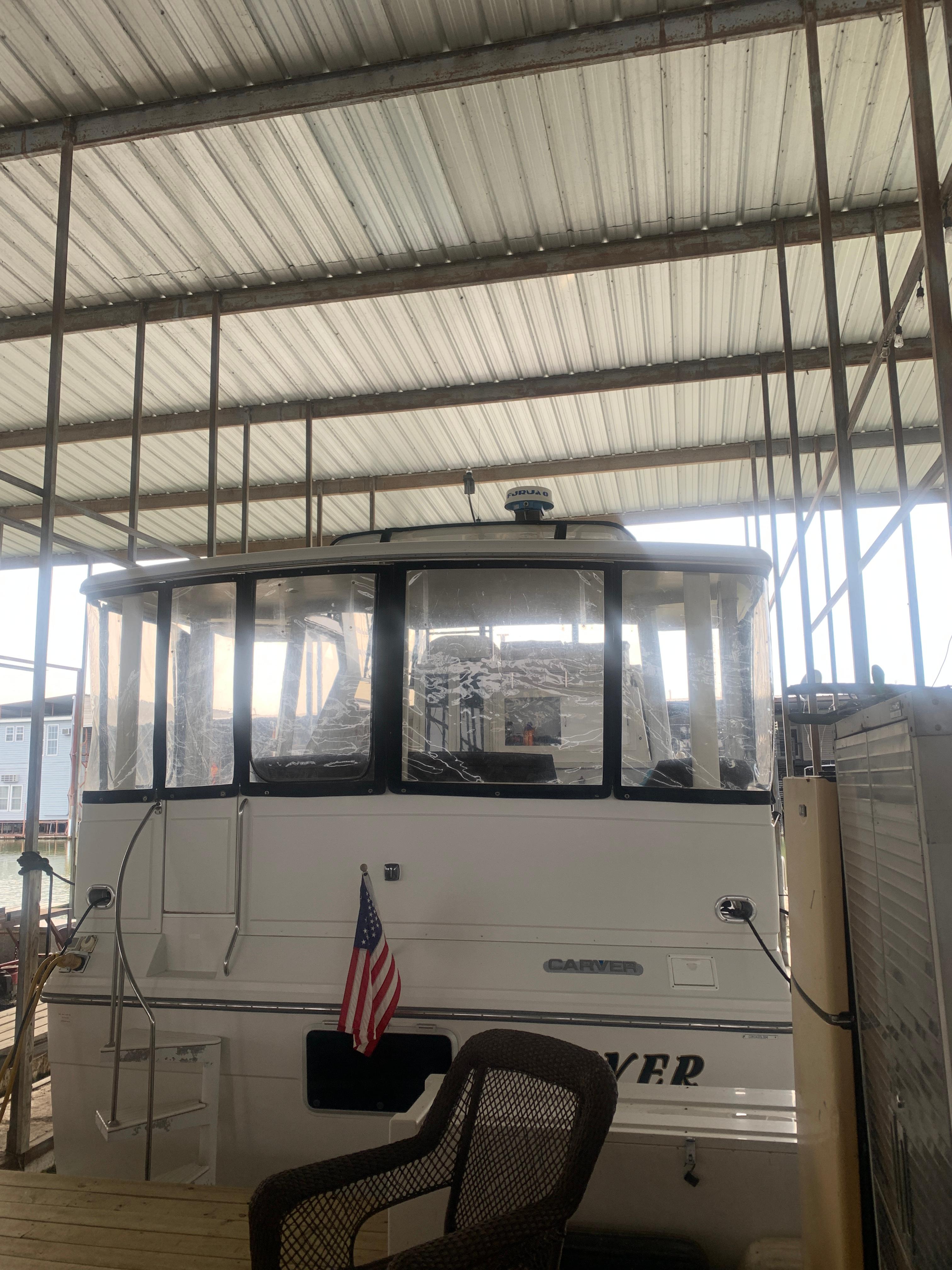 1994 Carver 440 Aft Cabin Motor Yacht docked under a covered marina.